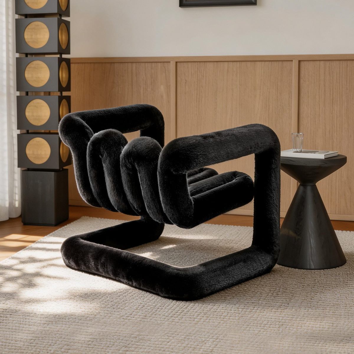 Rear angled view of the black 36.5°C Series sculptural plush lounge chair showing its curved channelled back