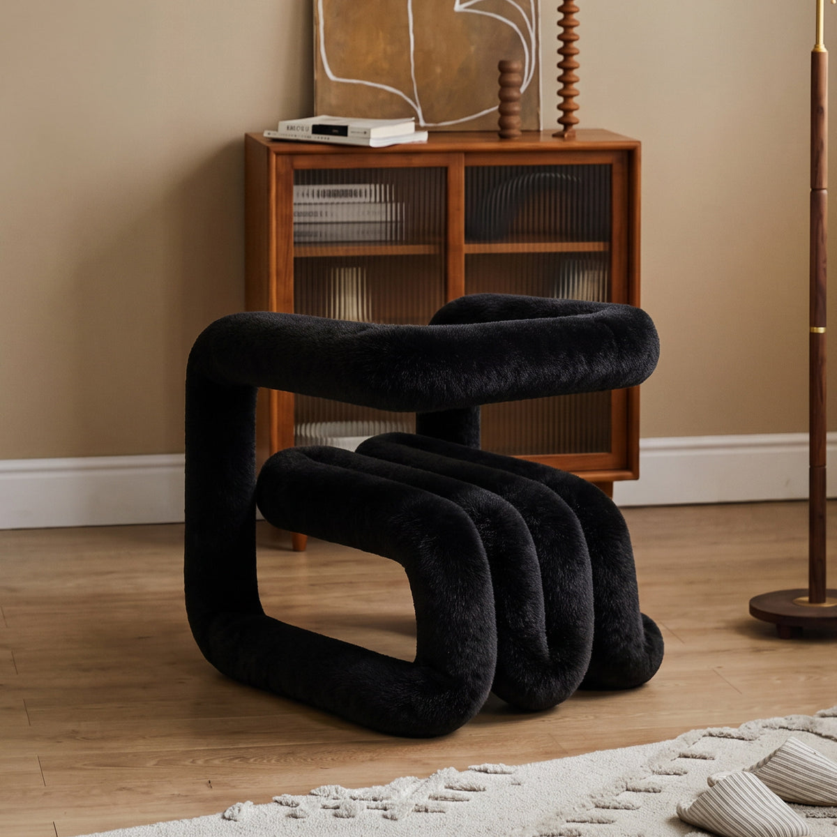 Black 36.5°C Series Medium-L plush accent chair in a warm contemporary living room with a sculptural looped silhouette