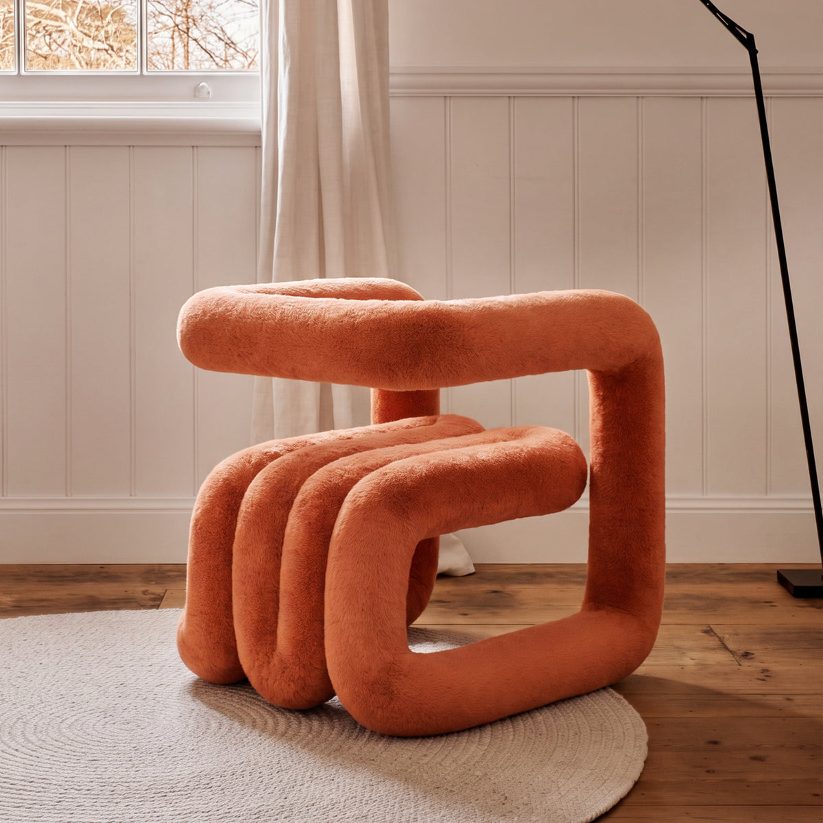 Side view of the orange 36.5°C Series Medium-L sculptural chair with cantilevered frame and rounded plush seating