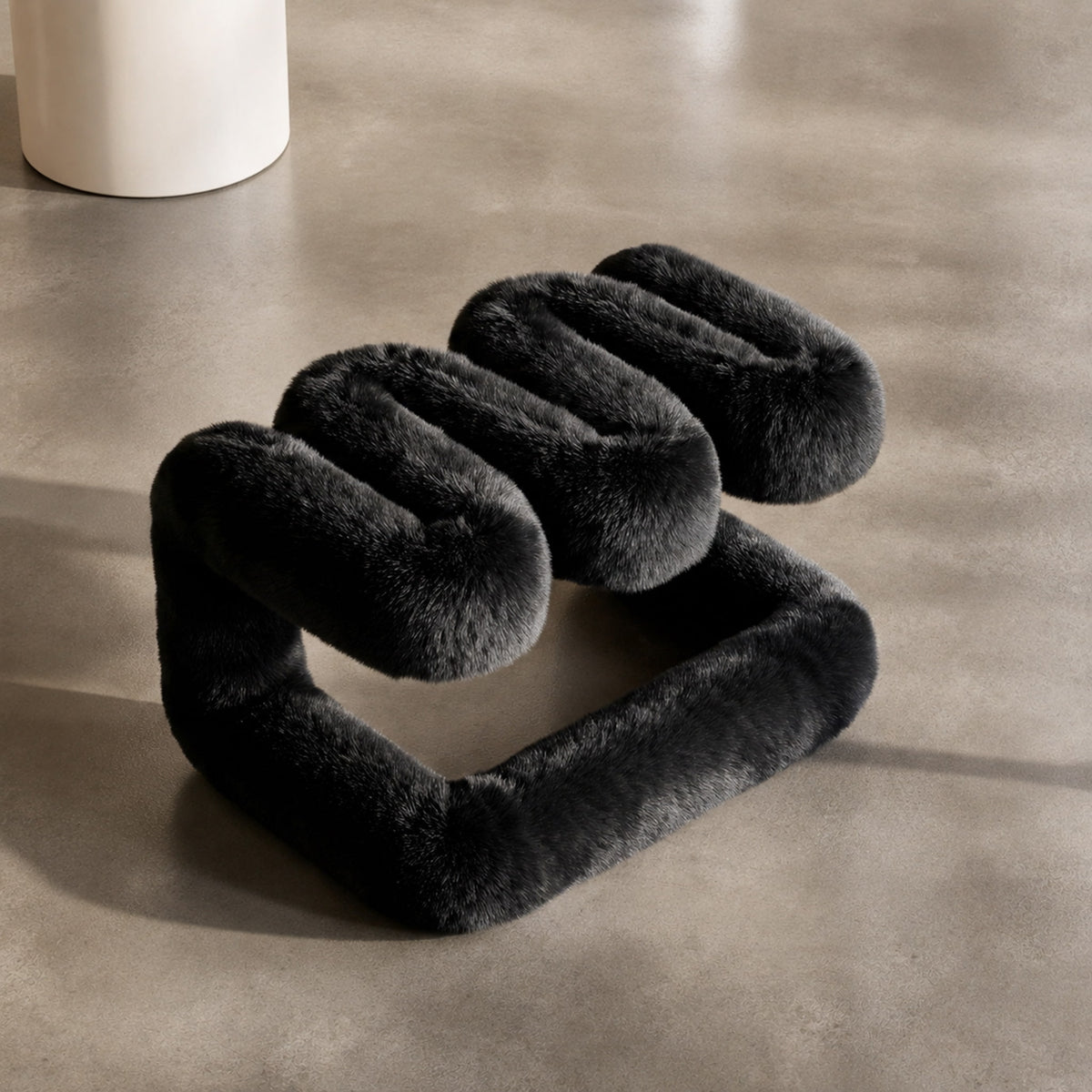 Elevated view of the black 36.5°C Series Plush Stool highlighting its playful wave-like construction.