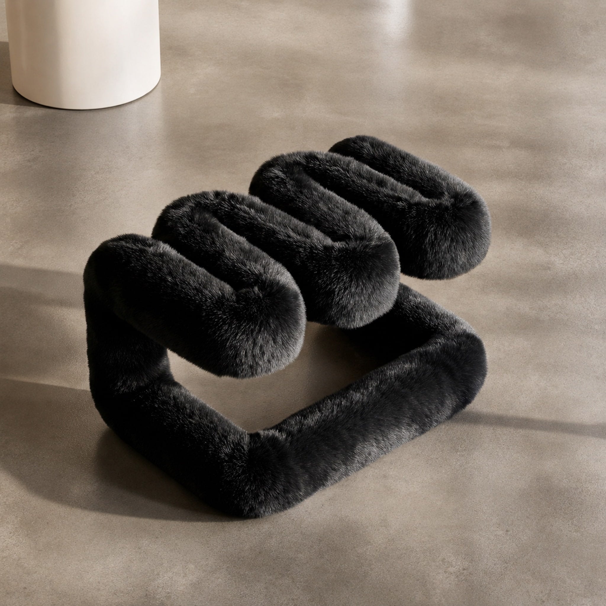Elevated view of the black 36.5°C Series Plush Stool highlighting its playful wave-like construction.