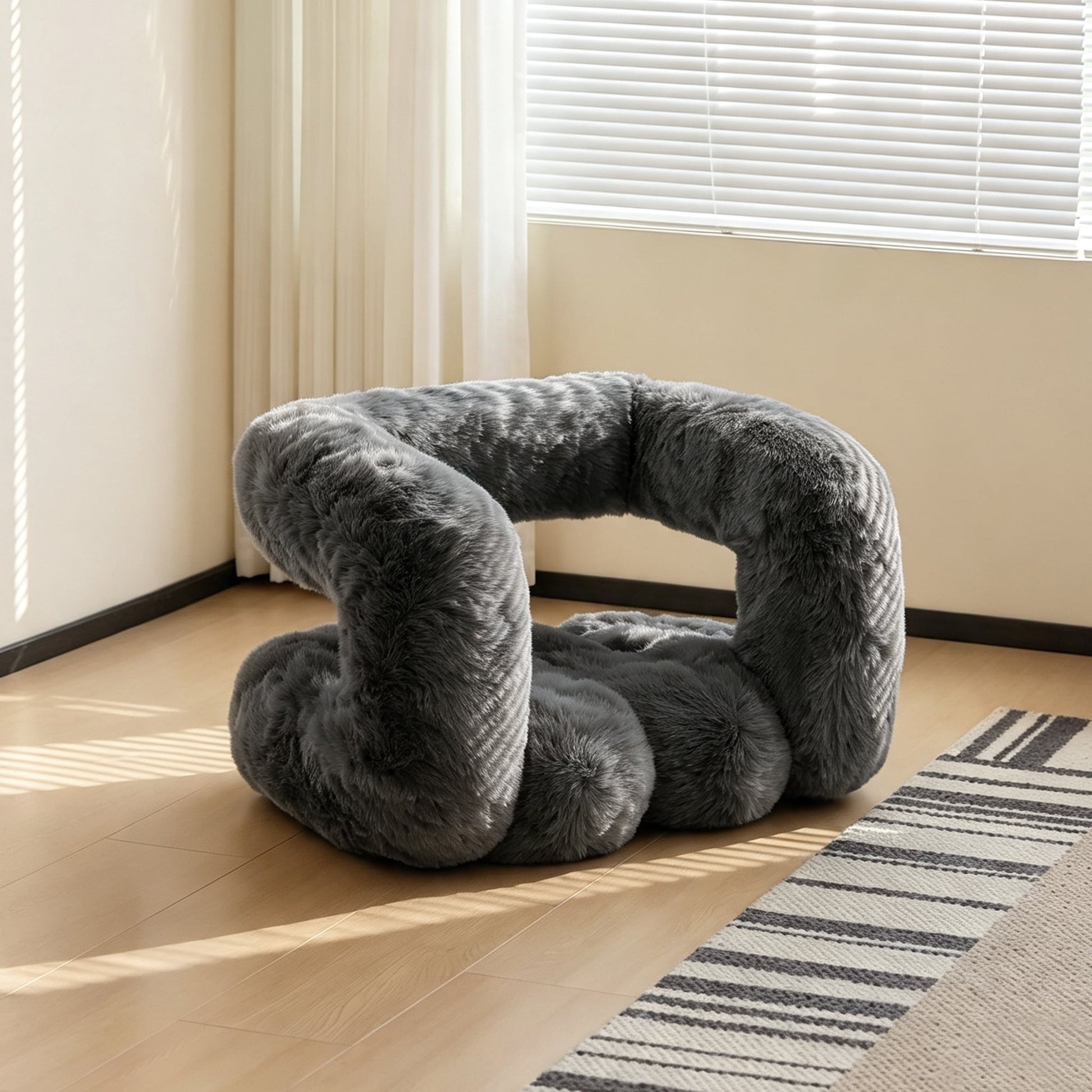 Side view of the charcoal gray 36.5°C Series Plush Stool showing its soft rounded wave-like form.