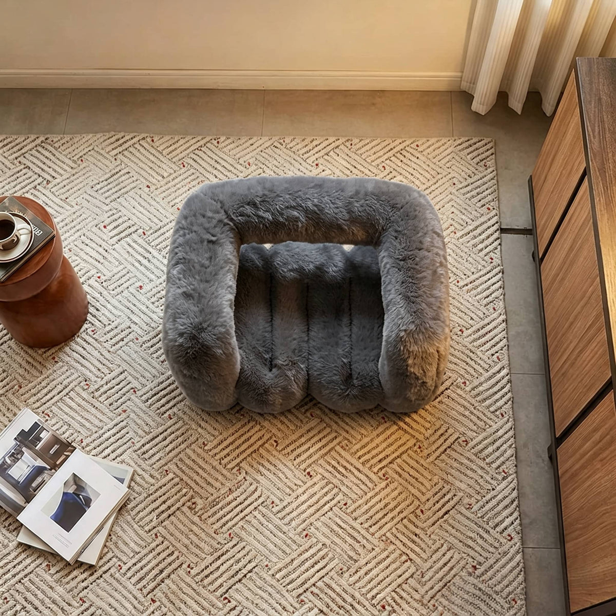 Overhead view of the charcoal gray 36.5°C Series Plush Stool on a textured rug in a contemporary interior.