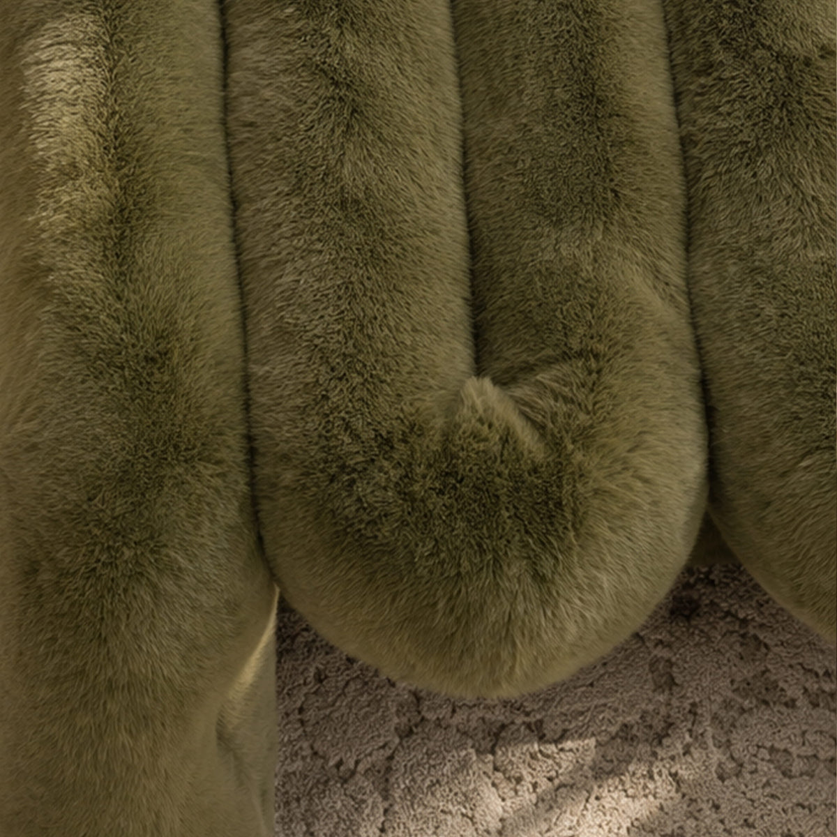 Close-up of the soft olive green eco-fur upholstery and rounded cushioning on the 36.5°C Series Plush Stool.