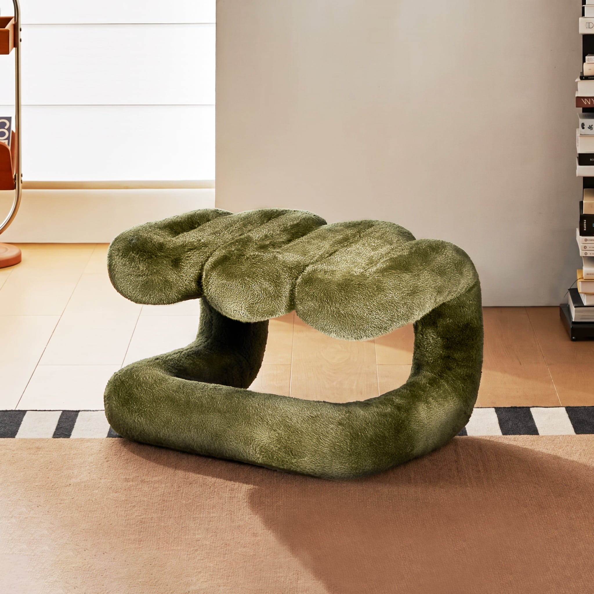 Olive green 36.5°C Series Plush Stool in a reversible sculptural configuration, styled on layered rugs in a warm modern living room.