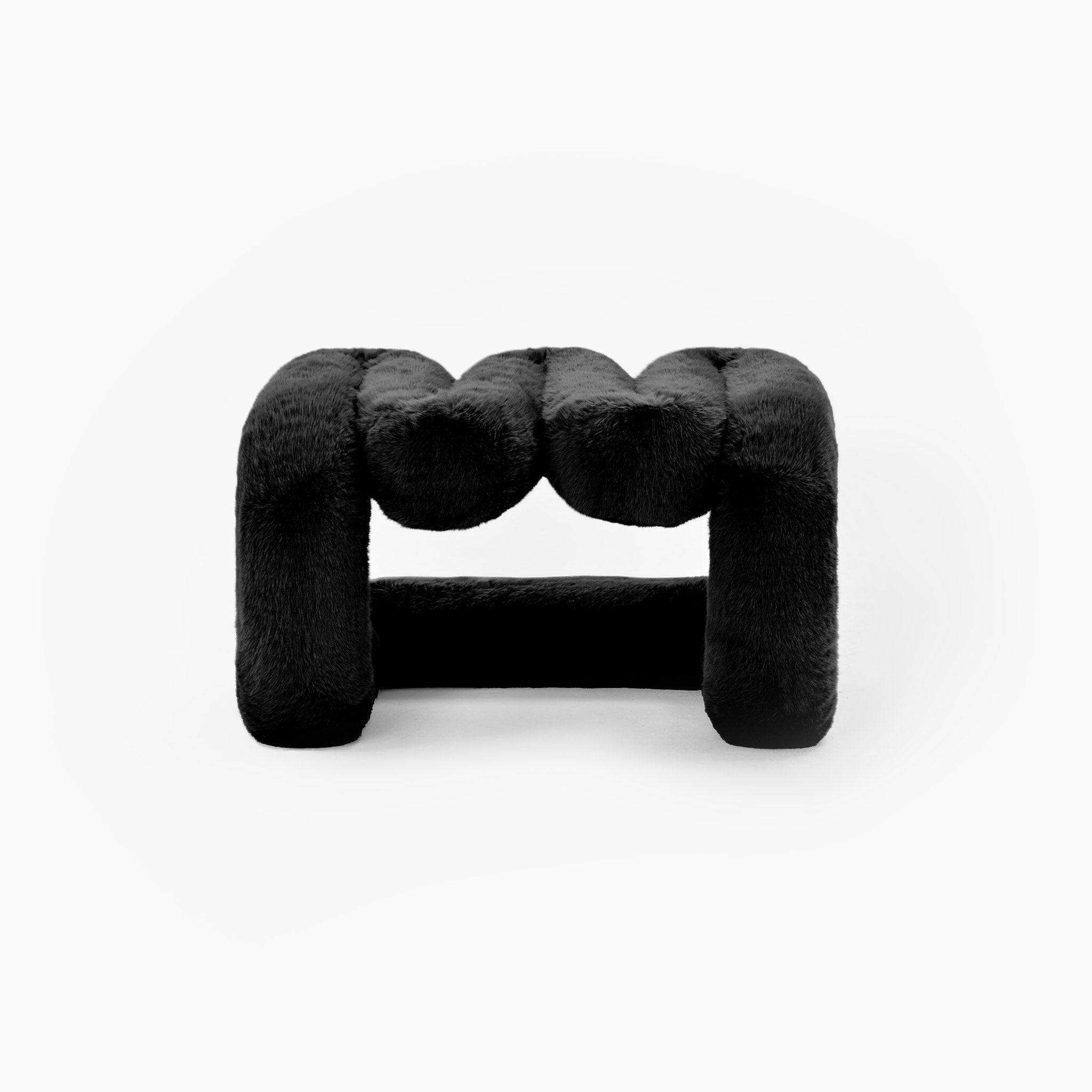 Sculptural black eco-fur lounge stool with modern wave design