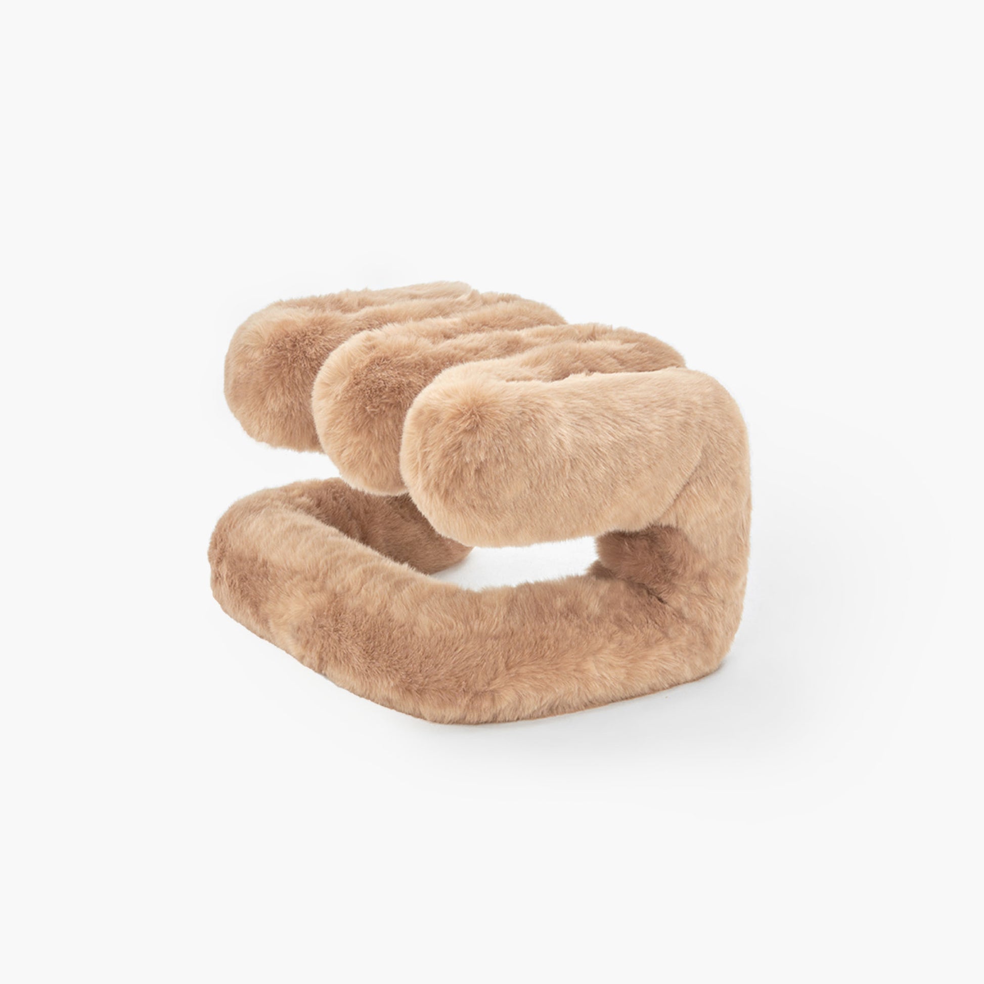 Sculptural brown plush ottoman resting on the floor