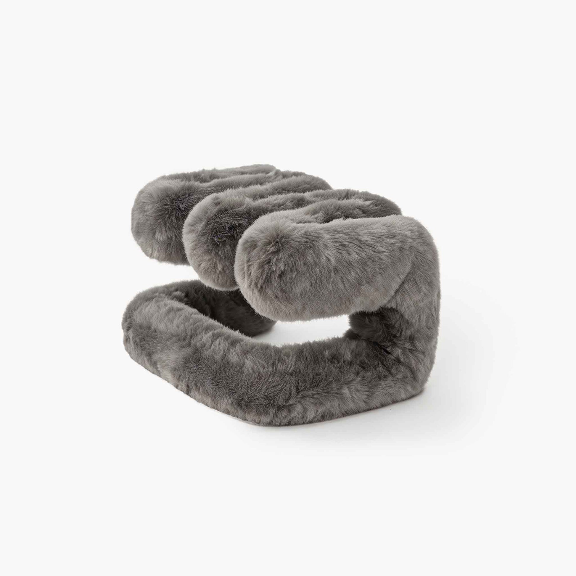 Sculptural grey plush ottoman resting on the floor