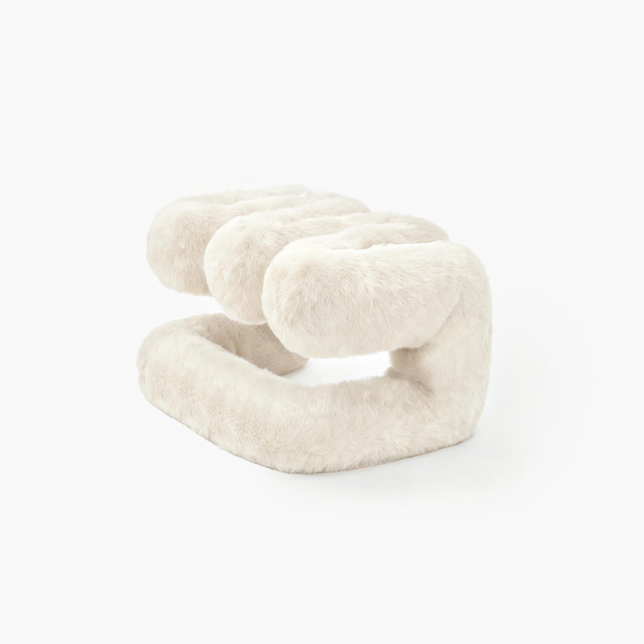 Sculptural white plush ottoman resting on the floor
