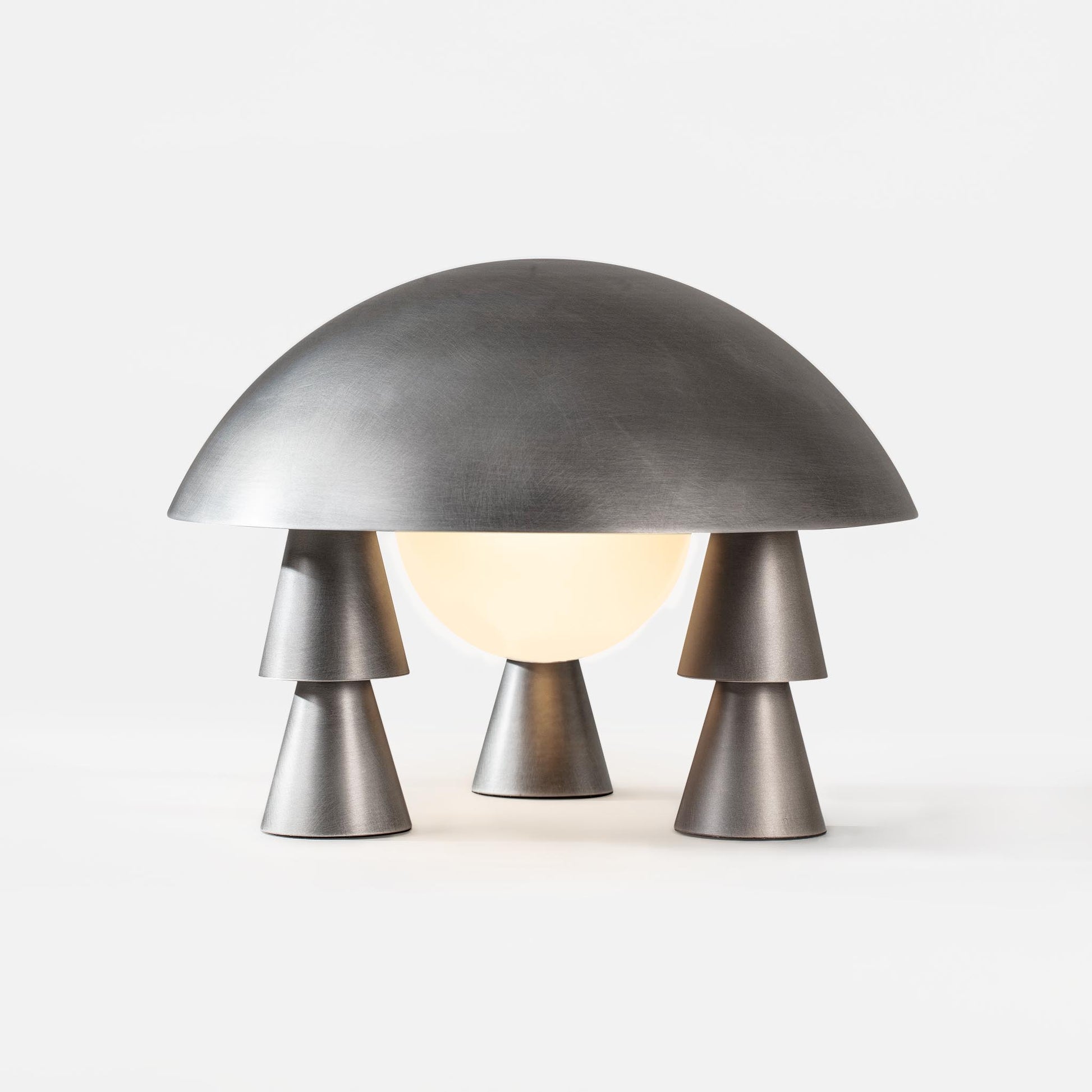 Illuminated space-age sculptural desk lamp featuring tiered metal legs
