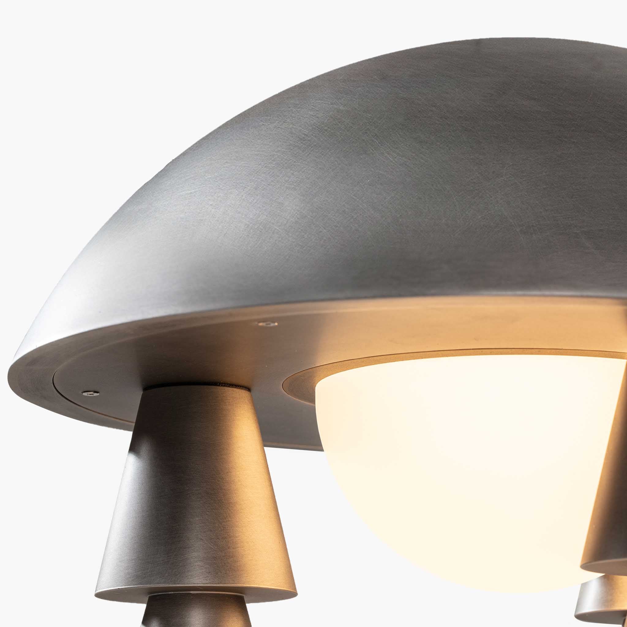 Close-up of the aged aluminum dome and frosted milky-white glass shade