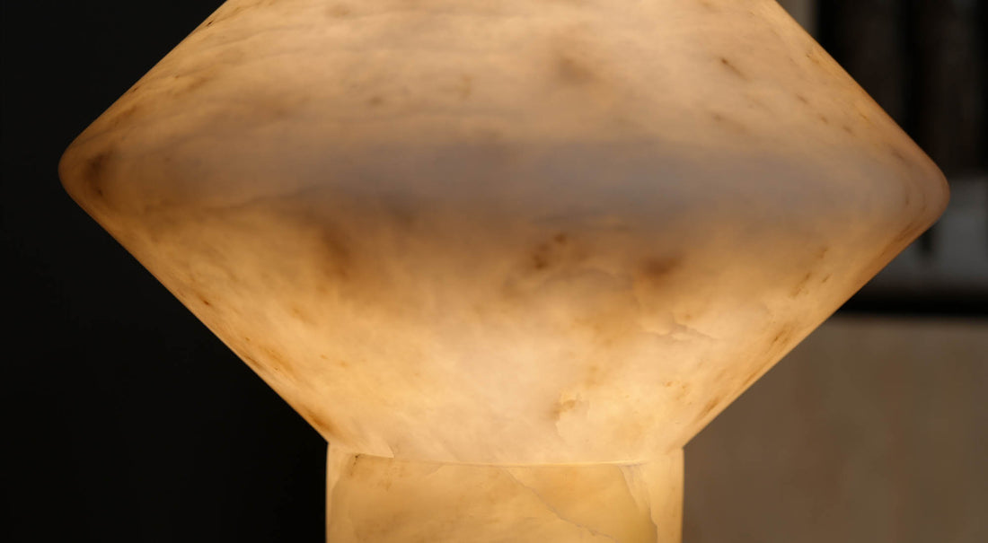 The artamore marble table lamp casts a carefully calibrated, warm ambient light, setting a calm and inviting mood in a modern wabi-sabi bedroom.