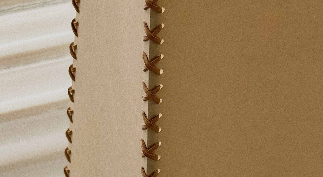 A macro shot of the artamore lamp's handcrafted parchment shade, revealing the one-of-a-kind natural wrinkles that reject mass-produced industrial uniformity.