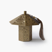 Exclusive hammered brass ambient lamp featuring a polyhedron silhouette and a delicate oriental decorative tassel.