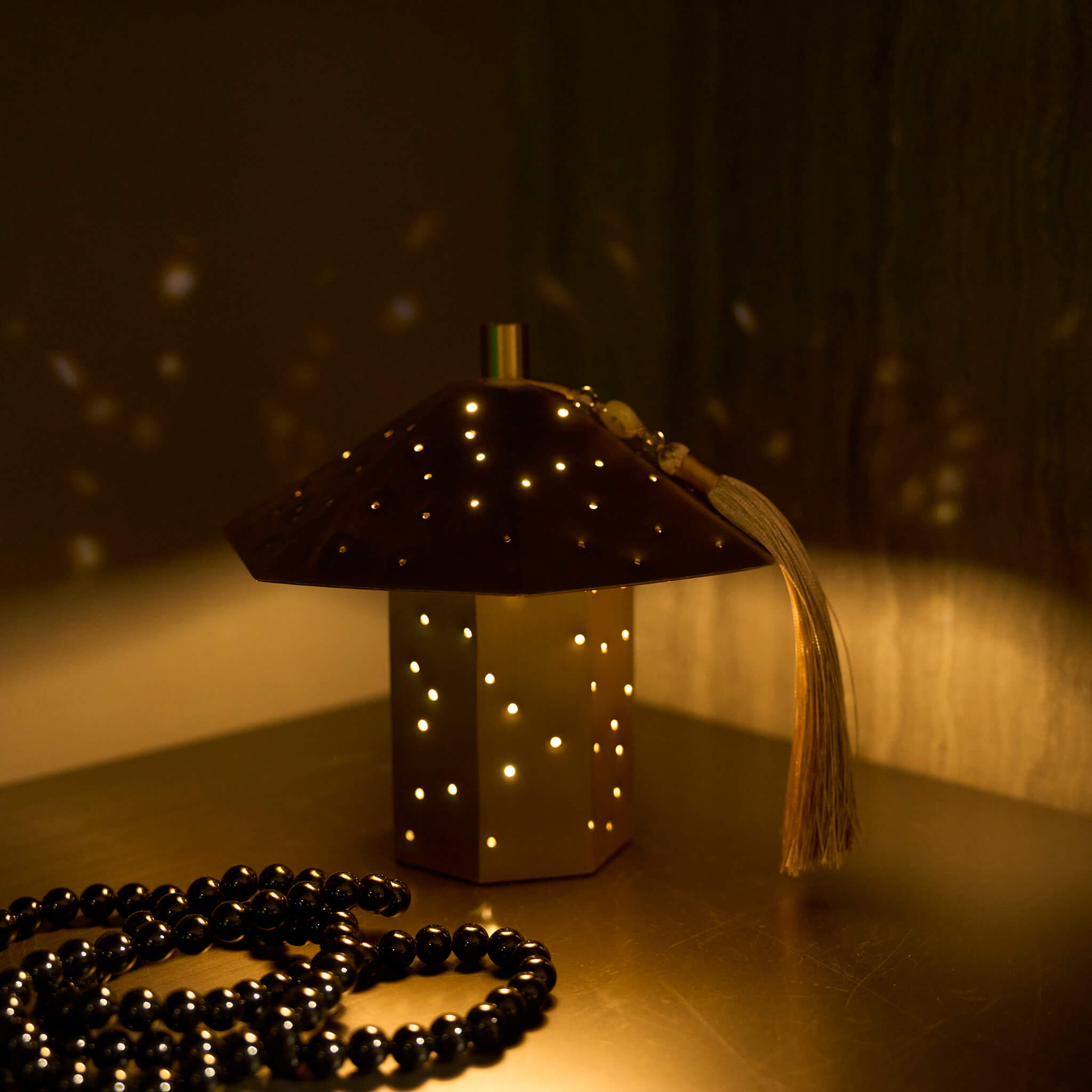 Elegant oriental ambient lighting styled on a modern dark wood bedside table, evoking a quiet luxury atmosphere.