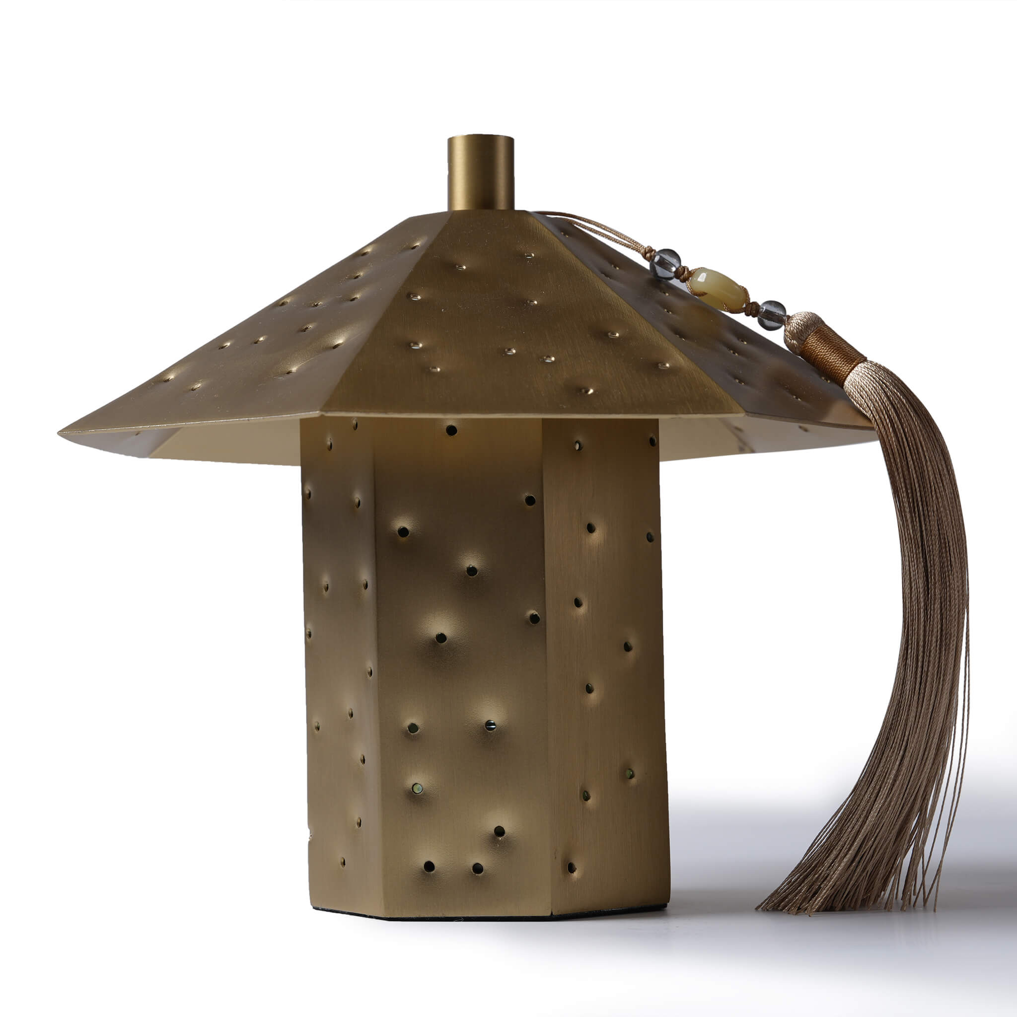 Close-up of the premium brushed thick metal and intricate hammered hole craftsmanship of the oriental table lamp.