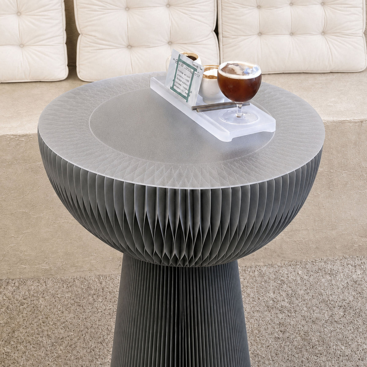 Grey Bouquet Side Table C with a frosted acrylic tabletop holding drinks in a contemporary lounge setting.