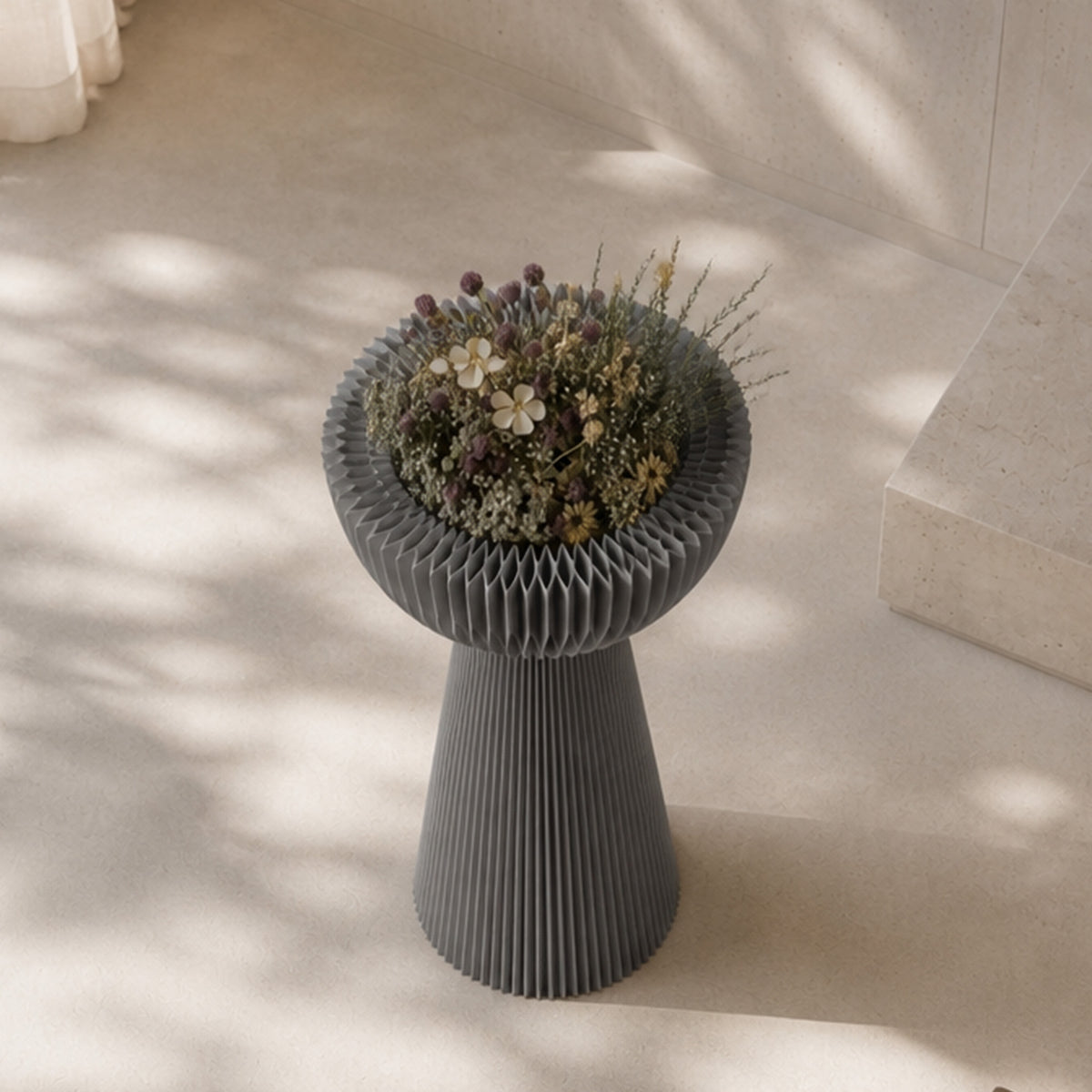 Grey Bouquet Side Table C used as a sculptural flower pedestal with a dried floral arrangement in a sunlit interior.