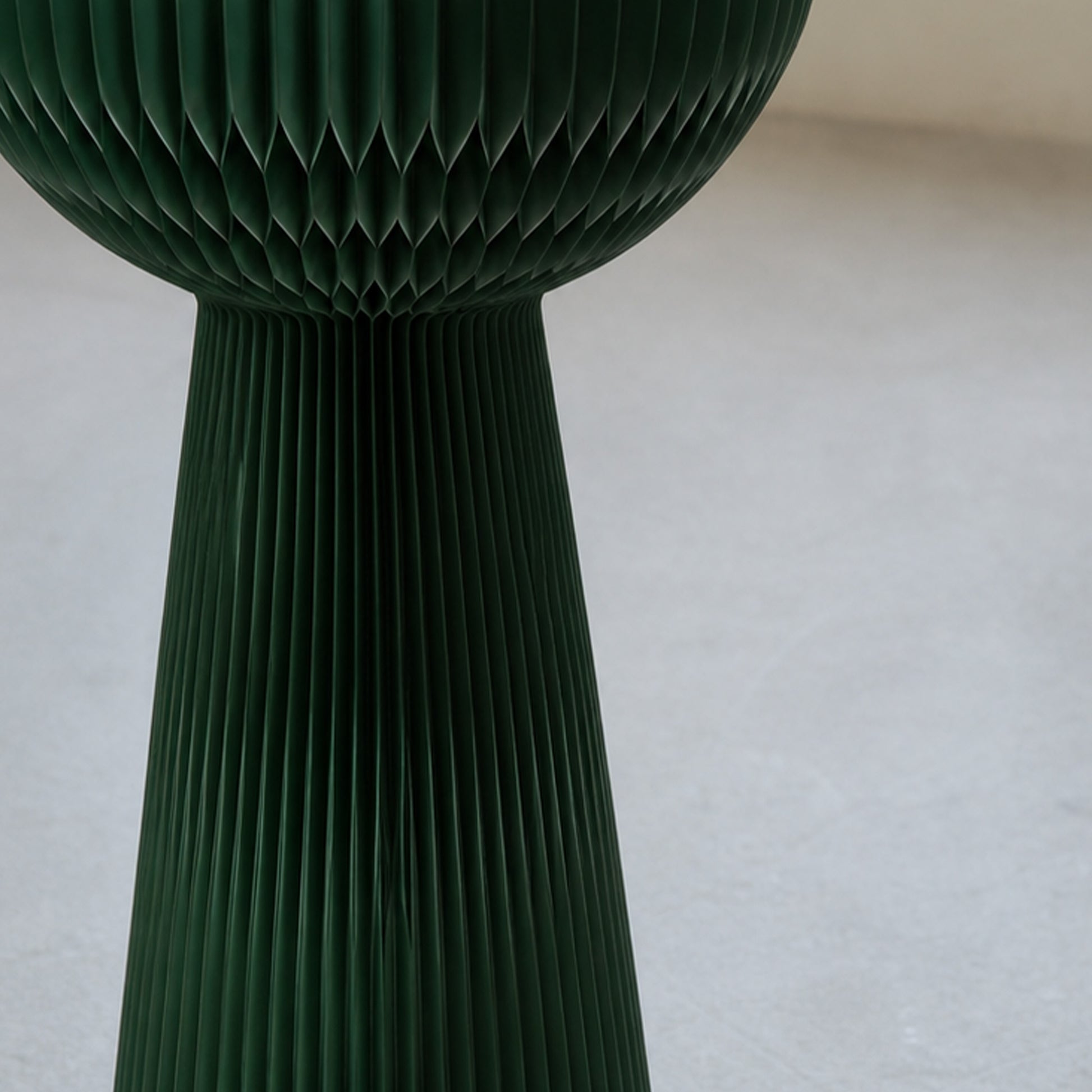 Close-up of the pine green Bouquet Side Table C showing its pleated honeycomb paper structure and sculptural form.