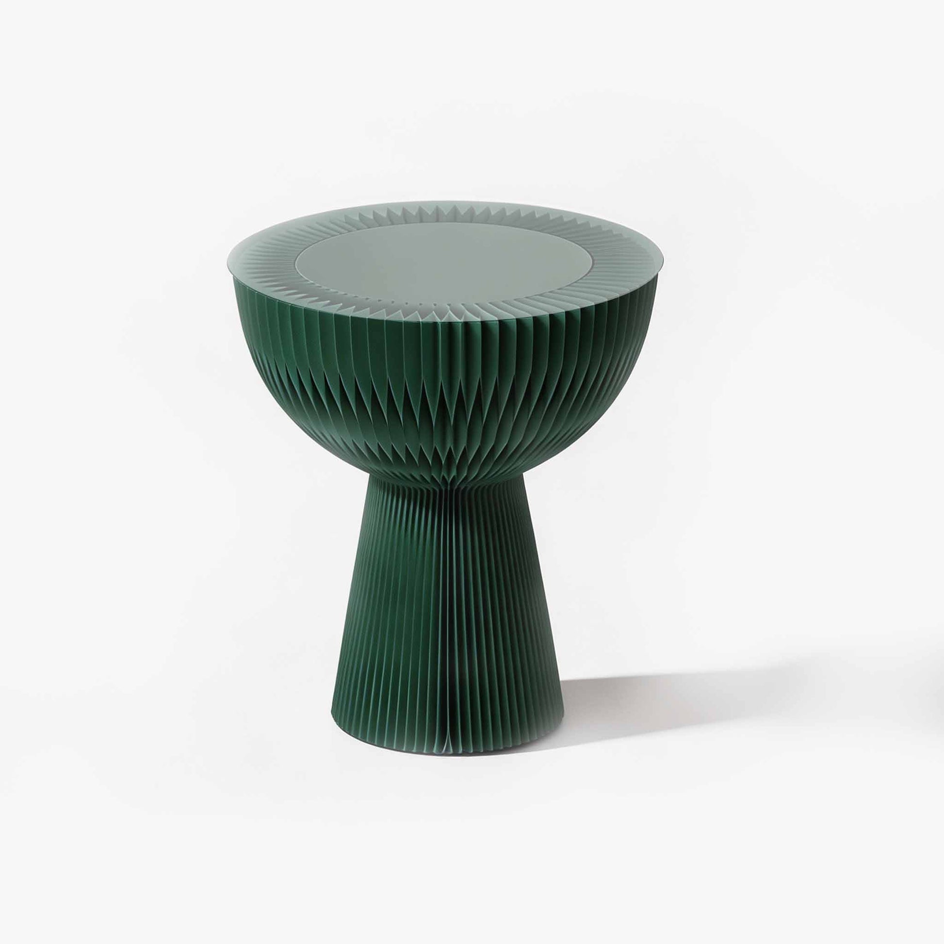 Pine green romantic foldable kraft paper end table curating a warm modern organic atmosphere by the sofa.