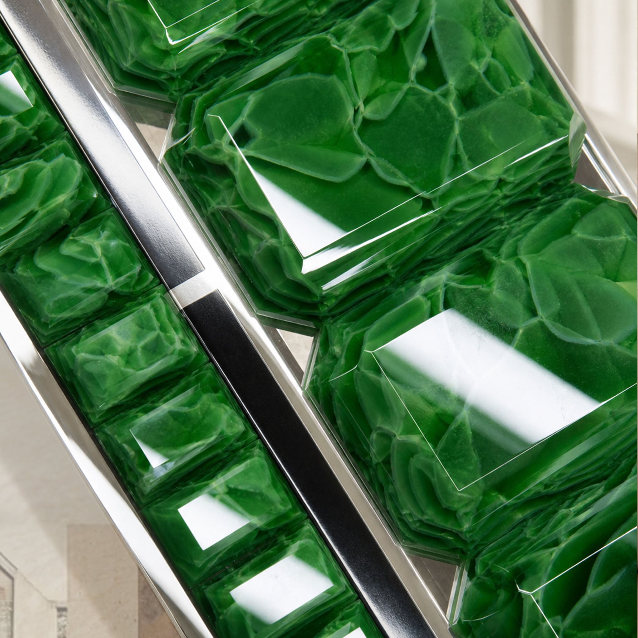 Close-up of Artamore Celebrity Mirror with emerald recycled glass blocks and polished metal frame.