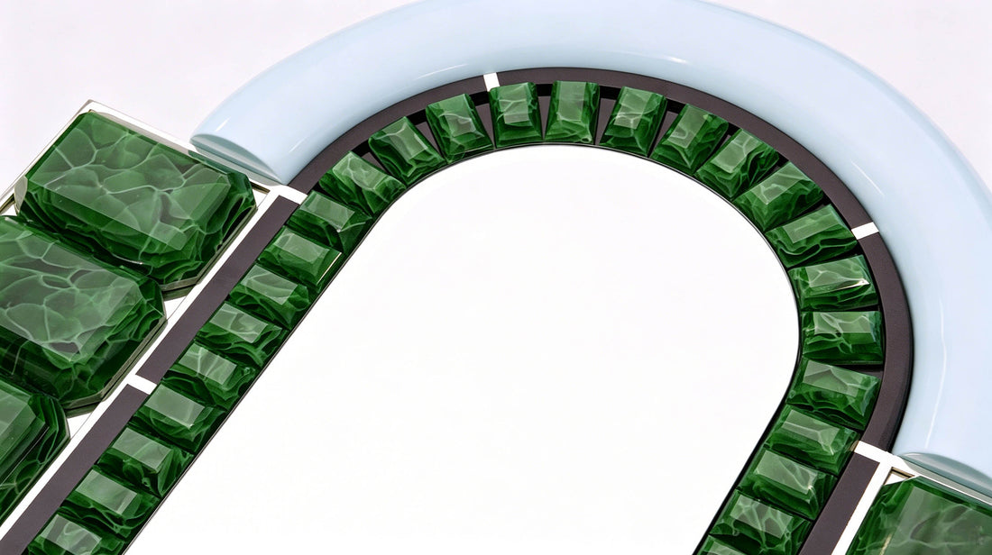 An angled view of the ARTAMORE Celebrity Mirror reflecting light through its unique emerald-toned glass, highlighting its role as both a functional mirror and a collectible art object.