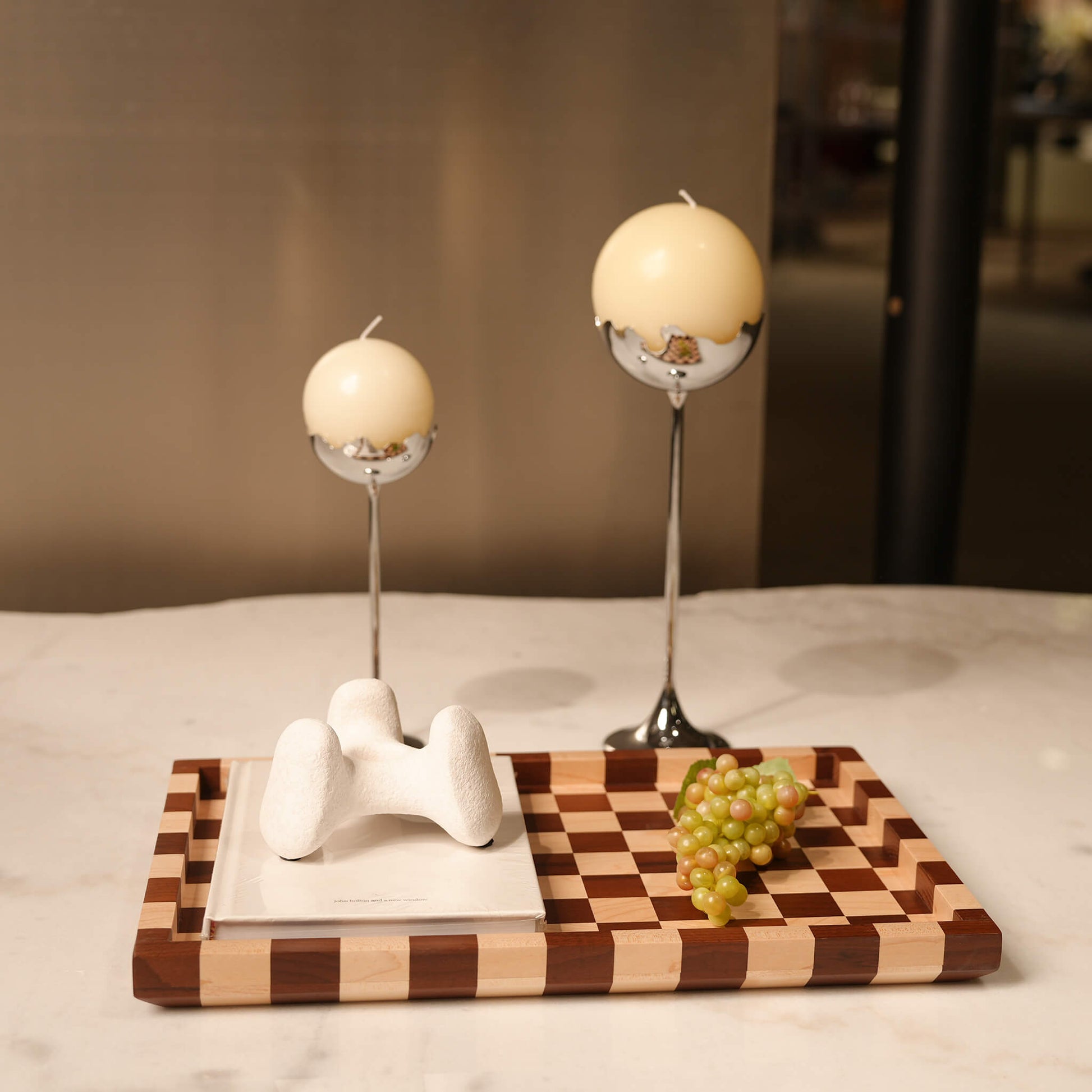 Geometric wooden decorative tray used as a sophisticated centrepiece with candles and fruit in a contemporary home