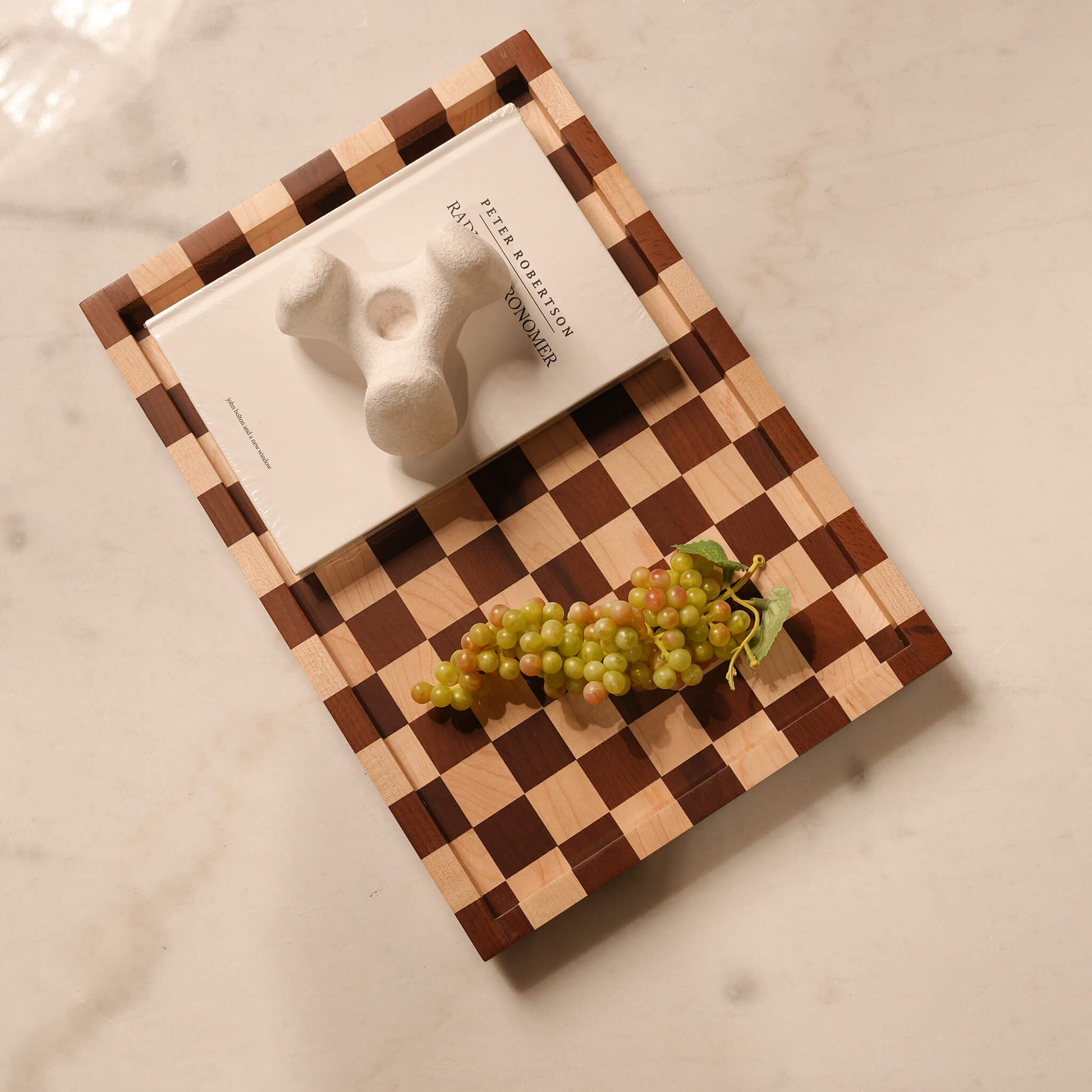 Multifunctional checkerboard tray beautifully organizing a white book and fresh fruit for elevated home decor