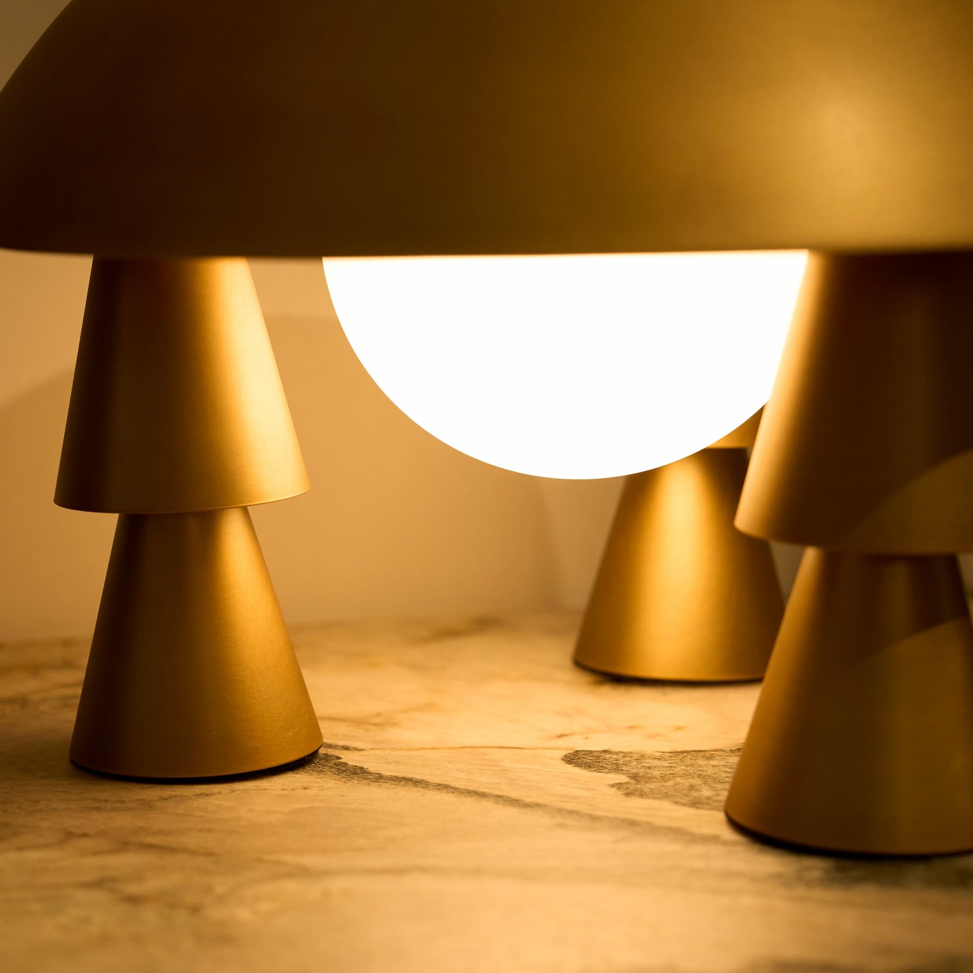 The cordless table lamp acting as a striking geometric centerpiece, with its illuminated frosted glass glowing against a dark background