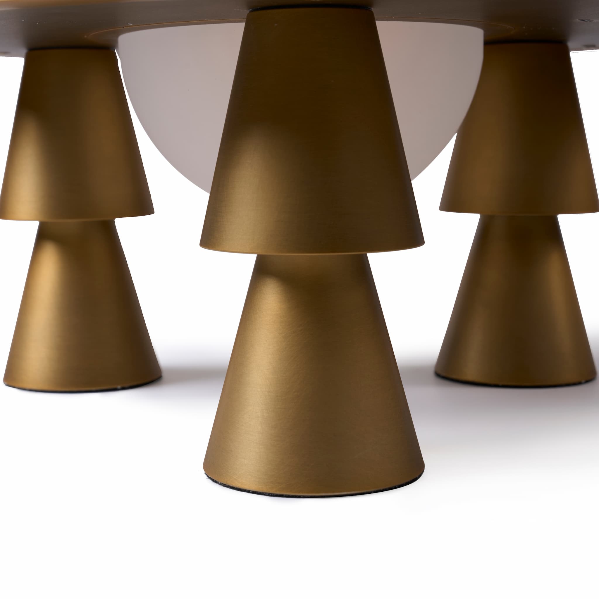 Detail view of the geometric conical legs and refined brass details of the space-age aesthetic lamp