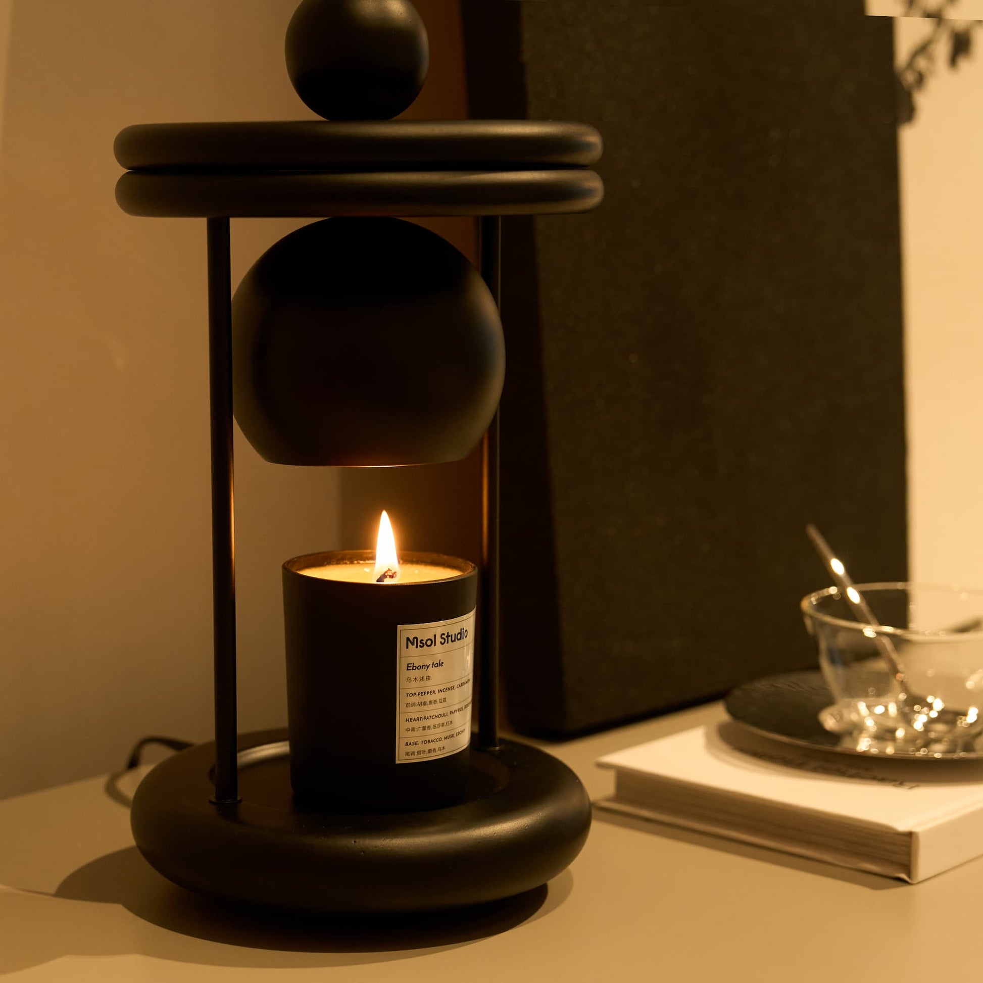 Side view showcasing the elegant matte black metal finish of the Dawn wax melting lamp.