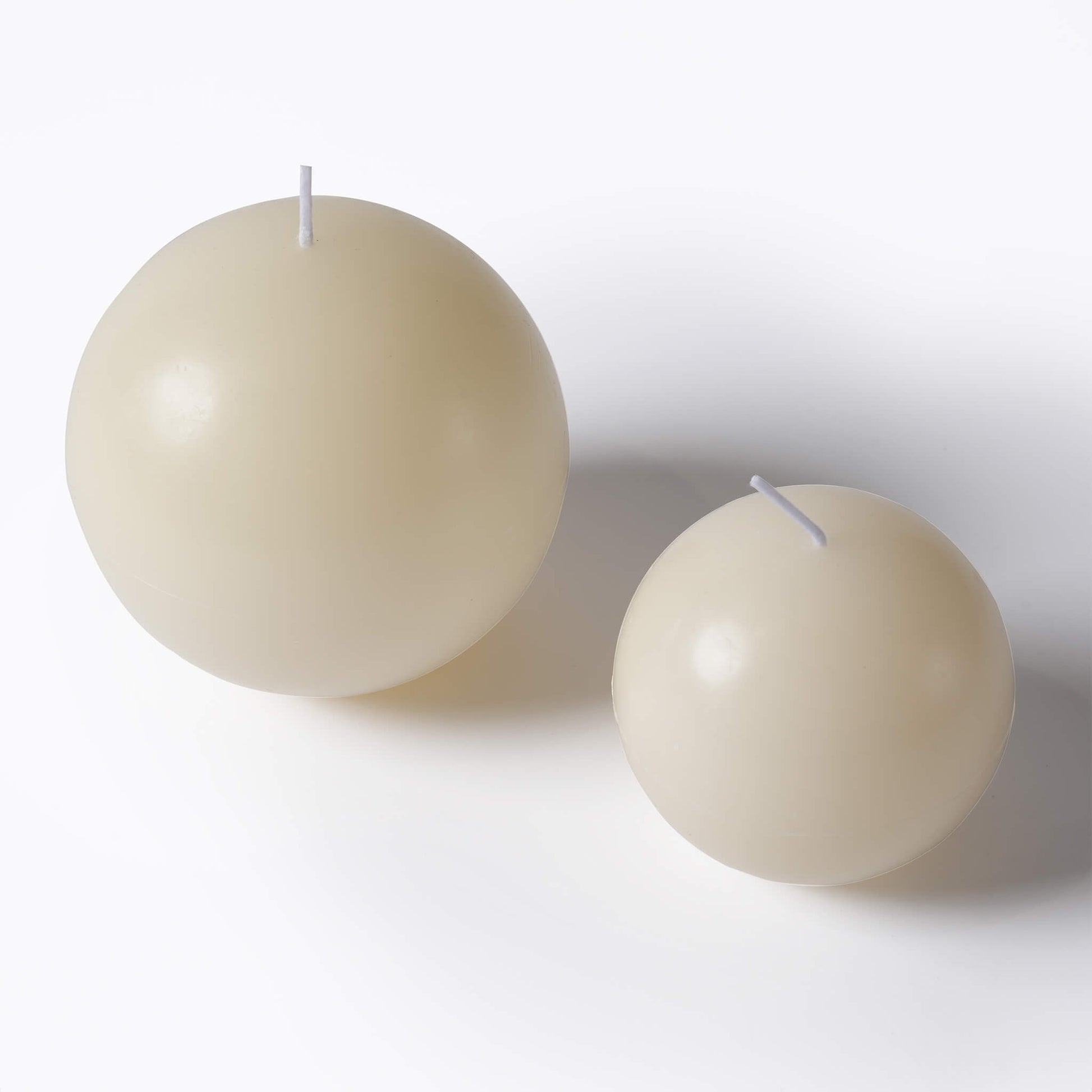 Top-angle view of the large and small sculptural egg scented candles , designed for long burn times of up to 24 hours