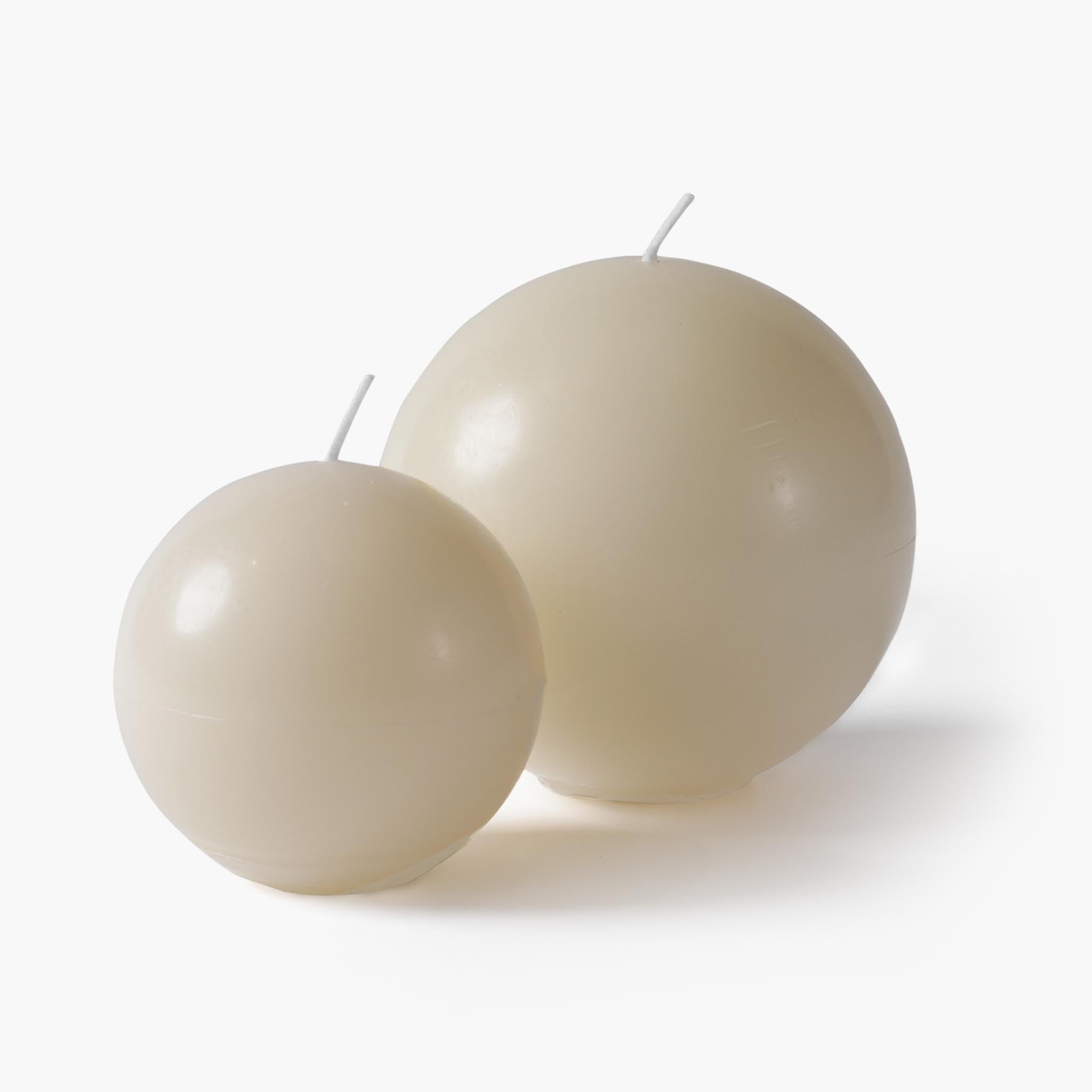 Two sizes of the sculptural egg-shaped scented candle in a minimalist cream finish , showing the large and small variations
