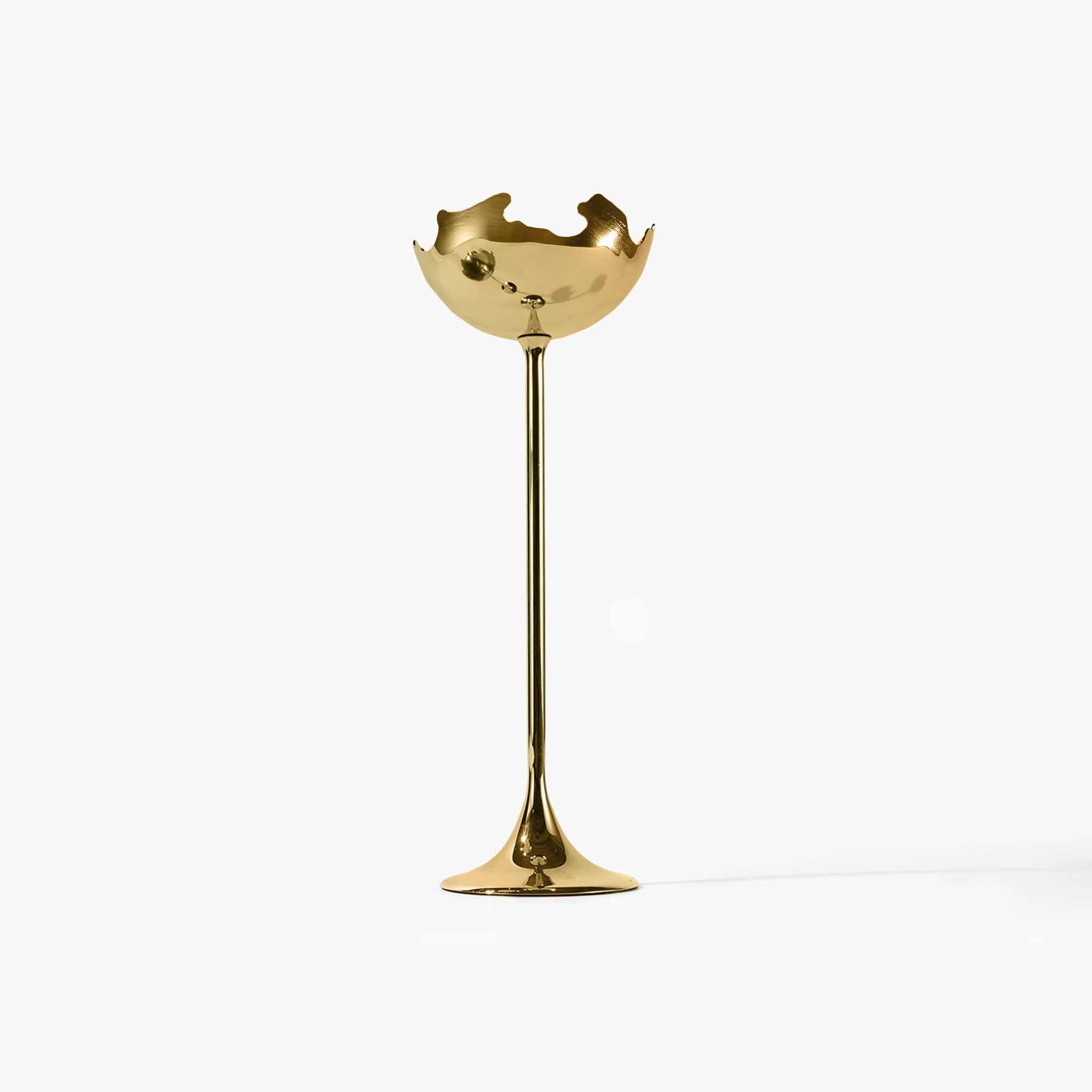 Detail of the solid metal sculptural candlestick showing its fluid lines and raw edges.