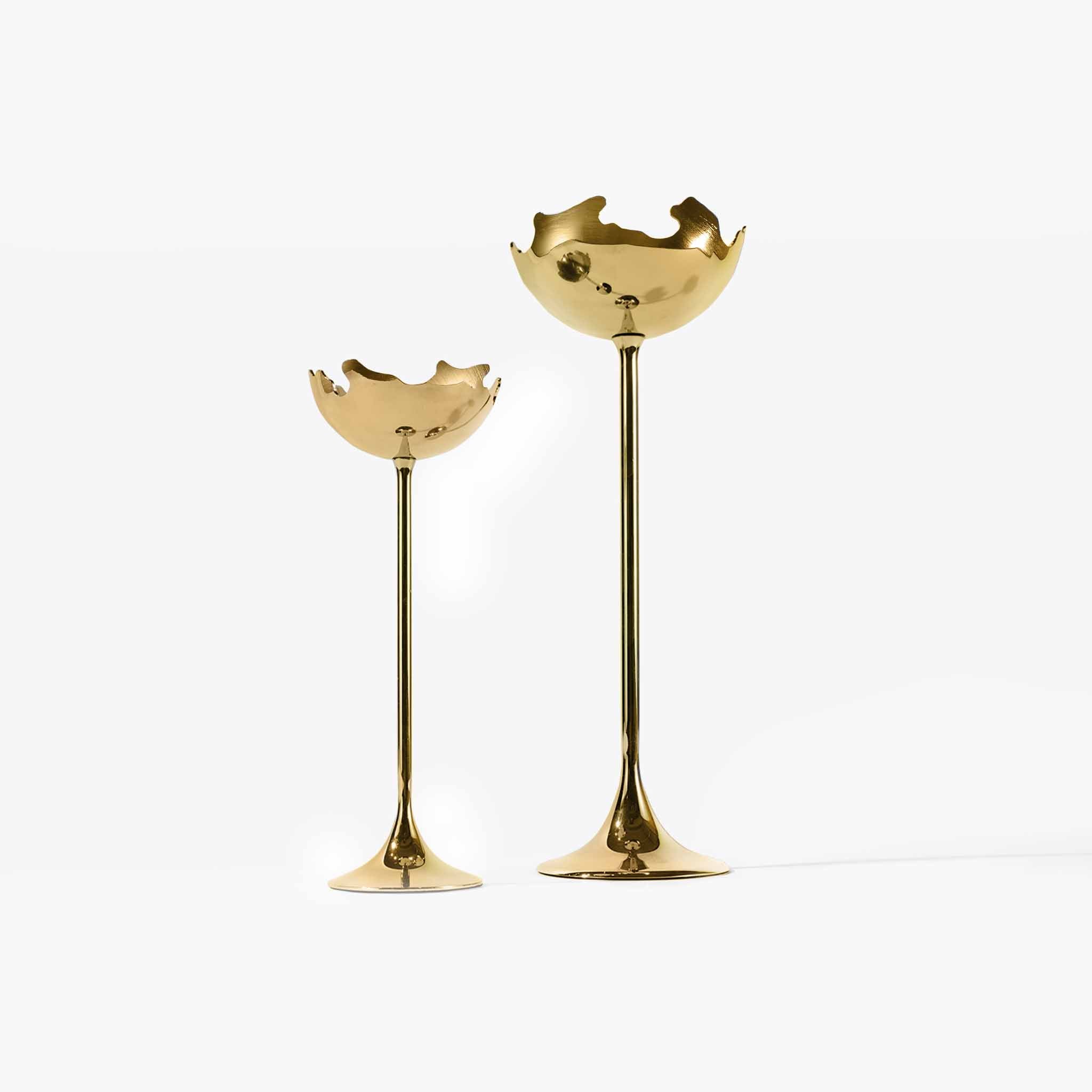 A curated set of large and small modern metallic candelabras in sunset gold.