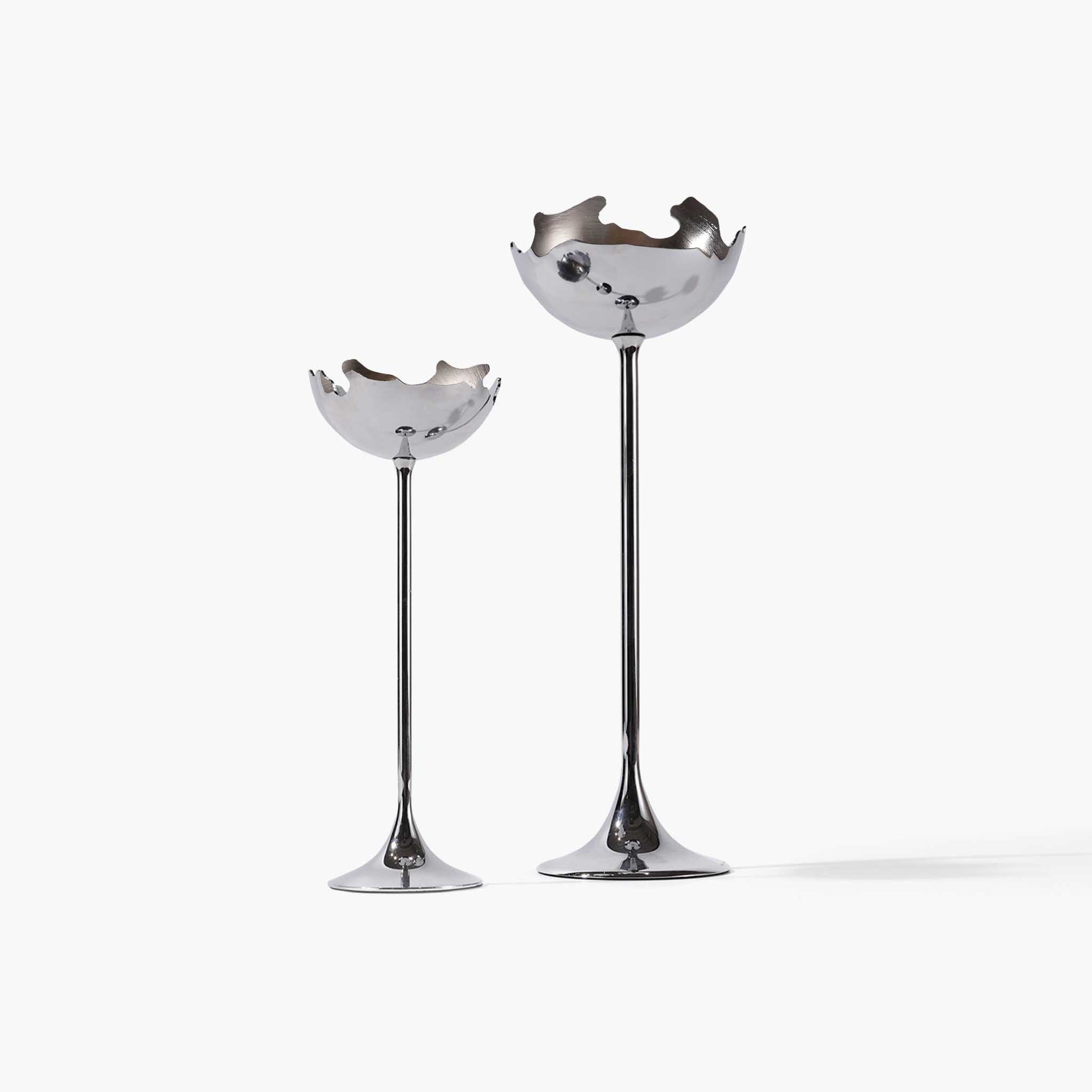 Set of two sculptural metal eggshell candle holders in the moonlight silver finish, showcasing their elegant stems and fluid lines