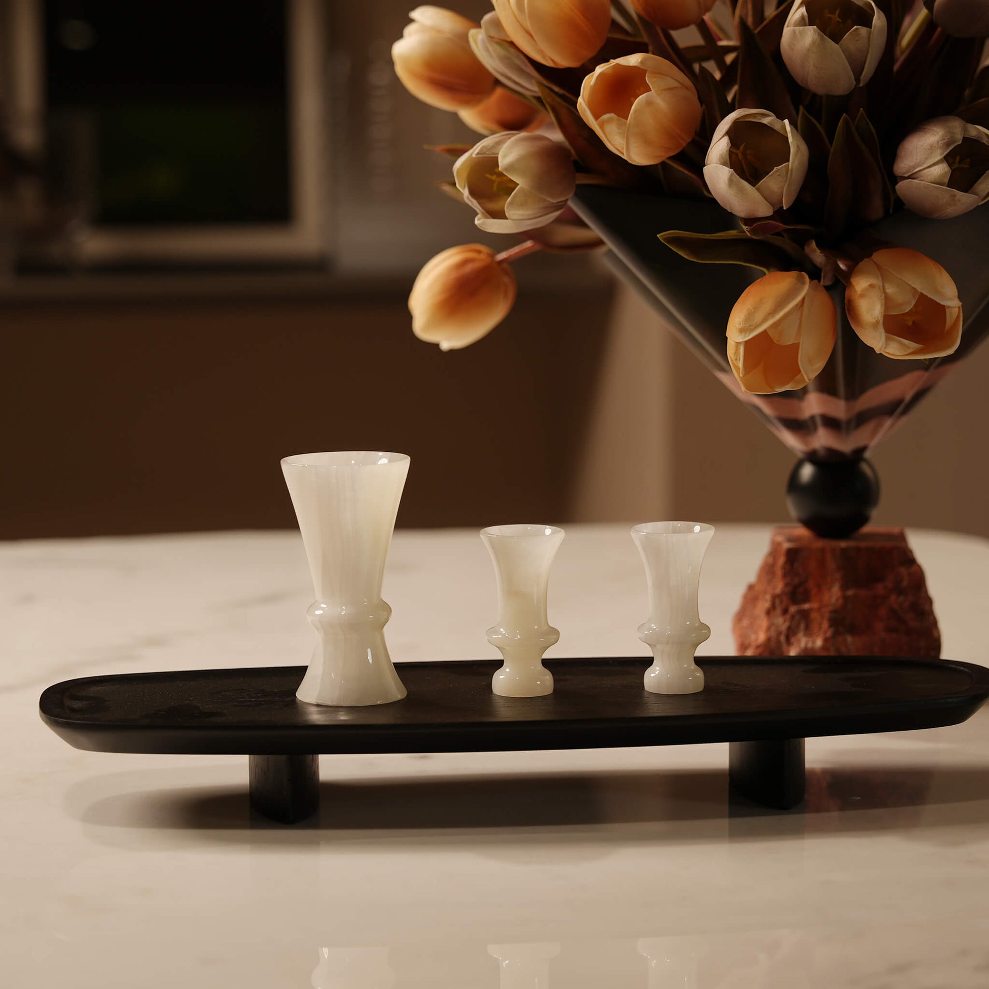 Close-up of a minimalist black wooden decorative tray beautifully organizing small decor pieces on a narrow surface
