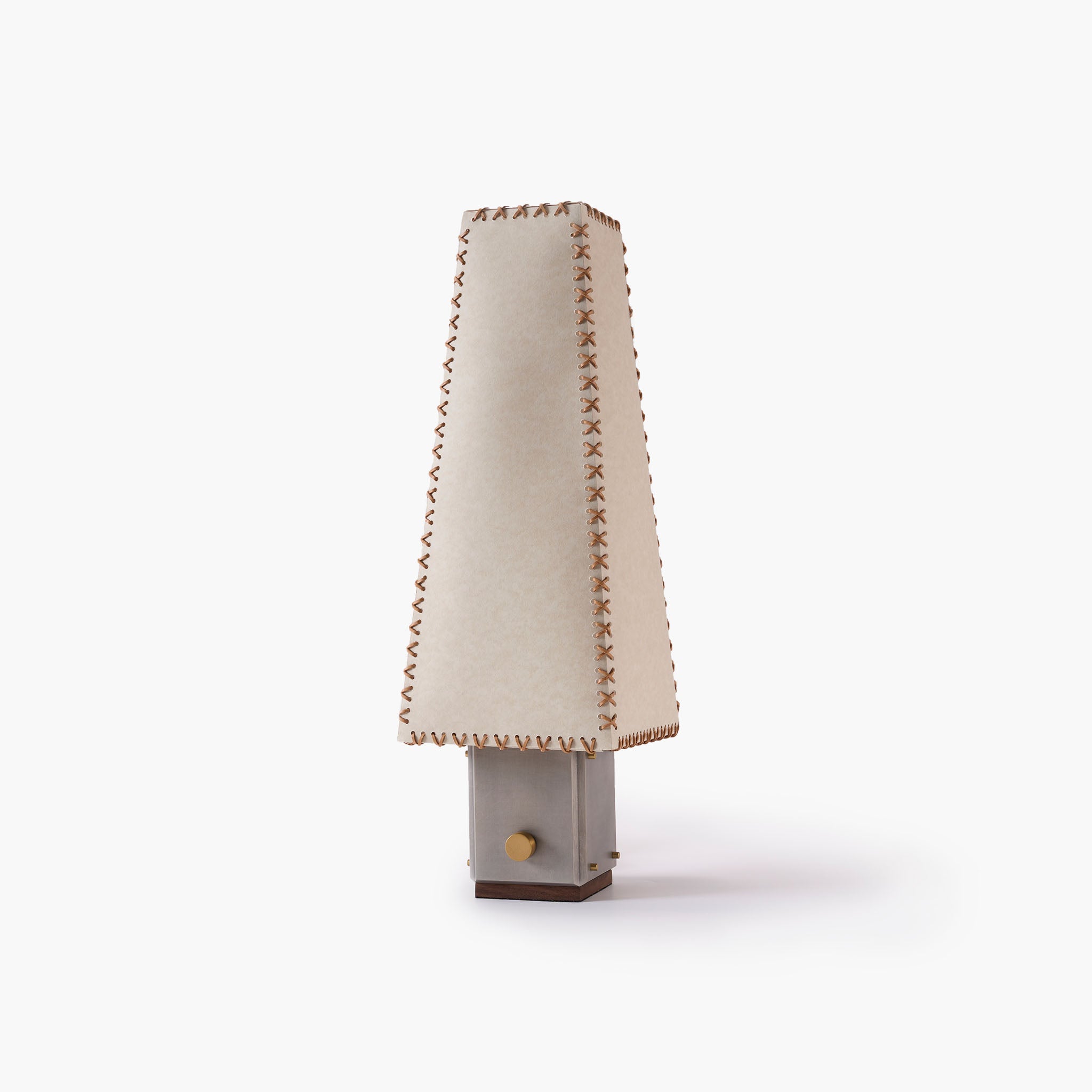 Handmade parchment table lamp with leather stitching and metal base.