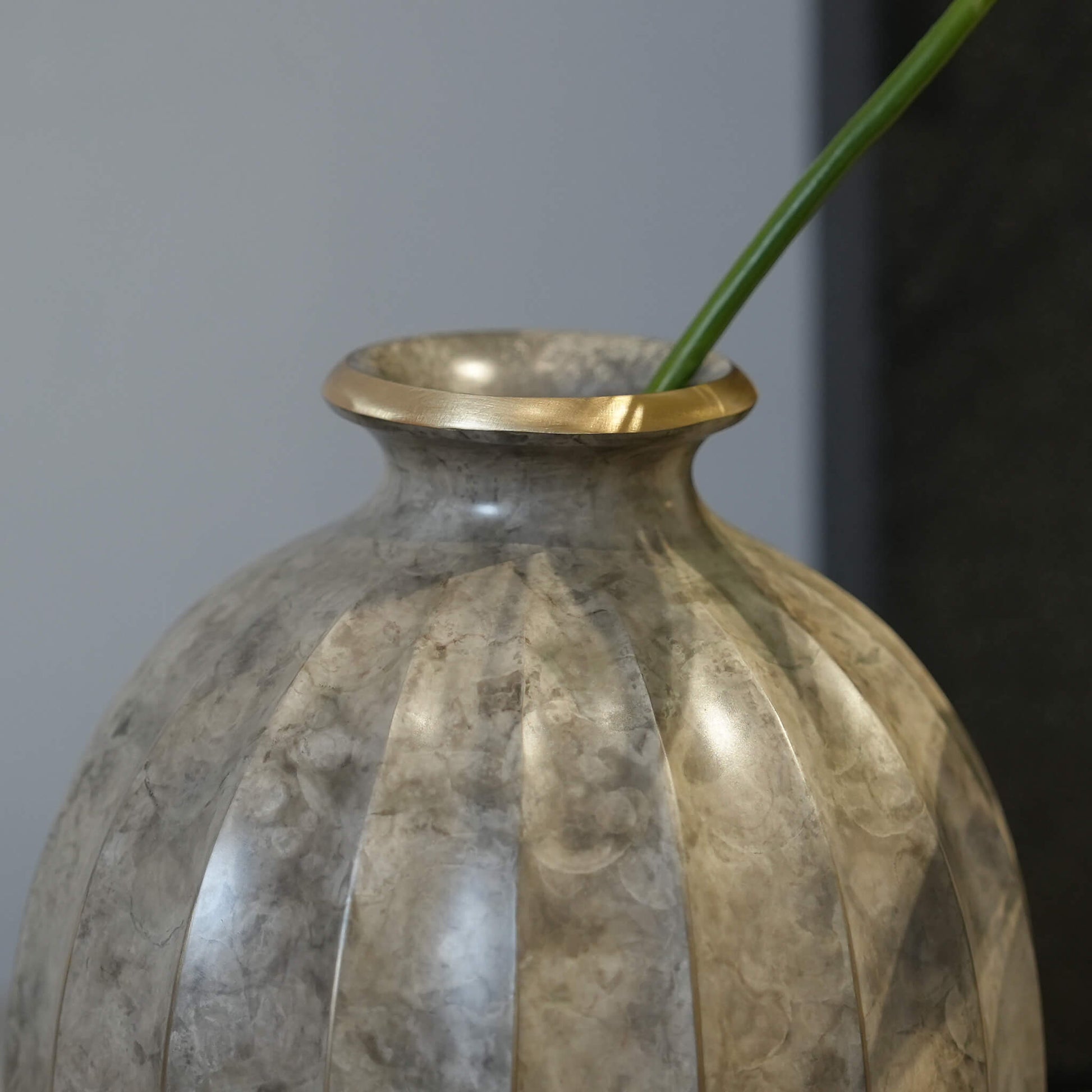 Detail highlighting the smooth curves and moist ethereal finish of the sculptural brass vessel.