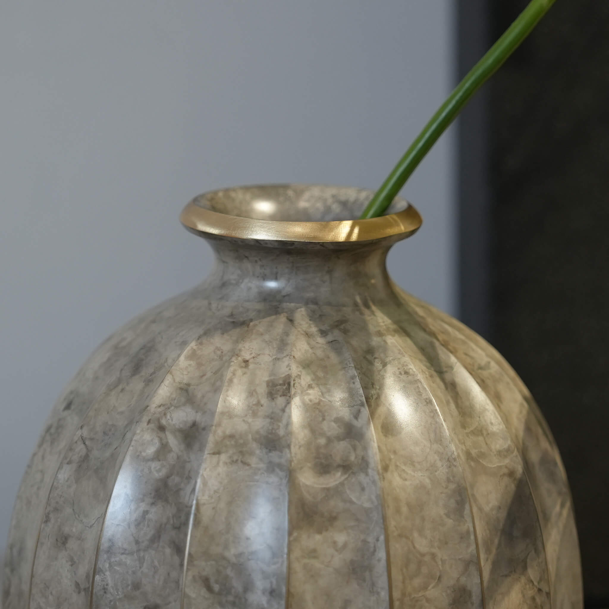 Detail highlighting the smooth curves and moist ethereal finish of the sculptural brass vessel.