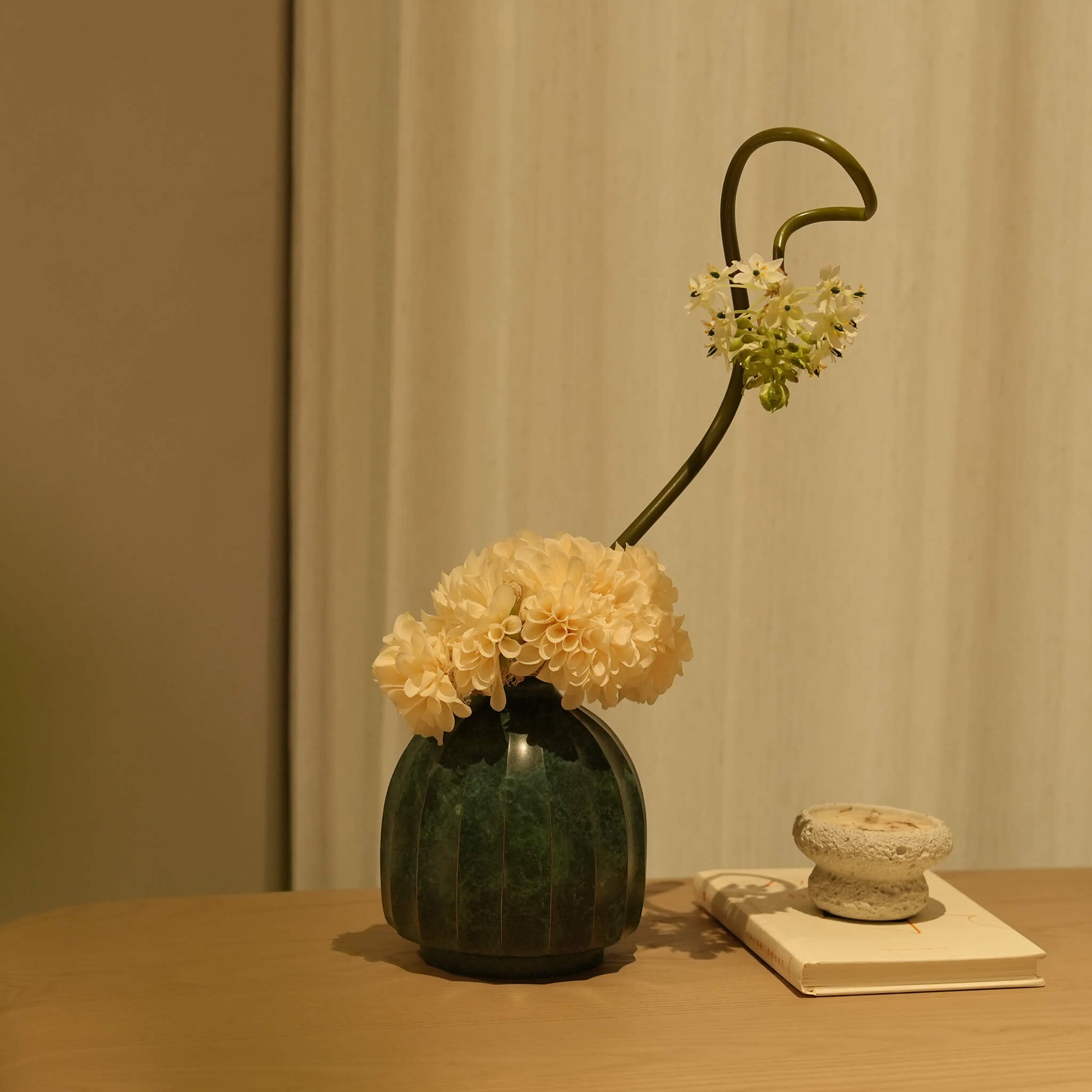 Quiet luxury solid brass vase displaying a curated, expansive floral arrangement.