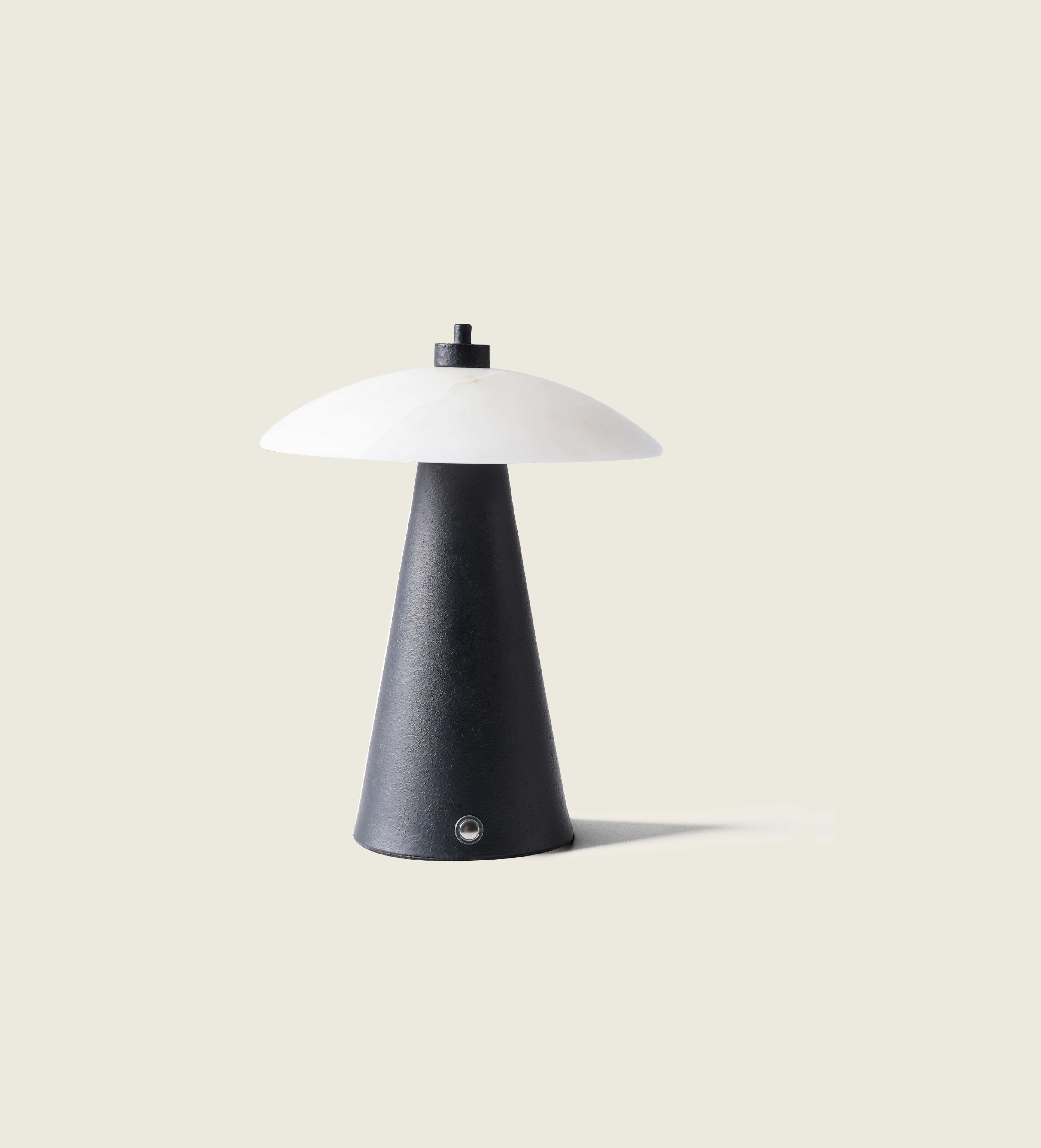 Close-up view of the artamore marble ambient lamp, highlighting the unique natural veining of the stone contrasted against the solid black metal body.