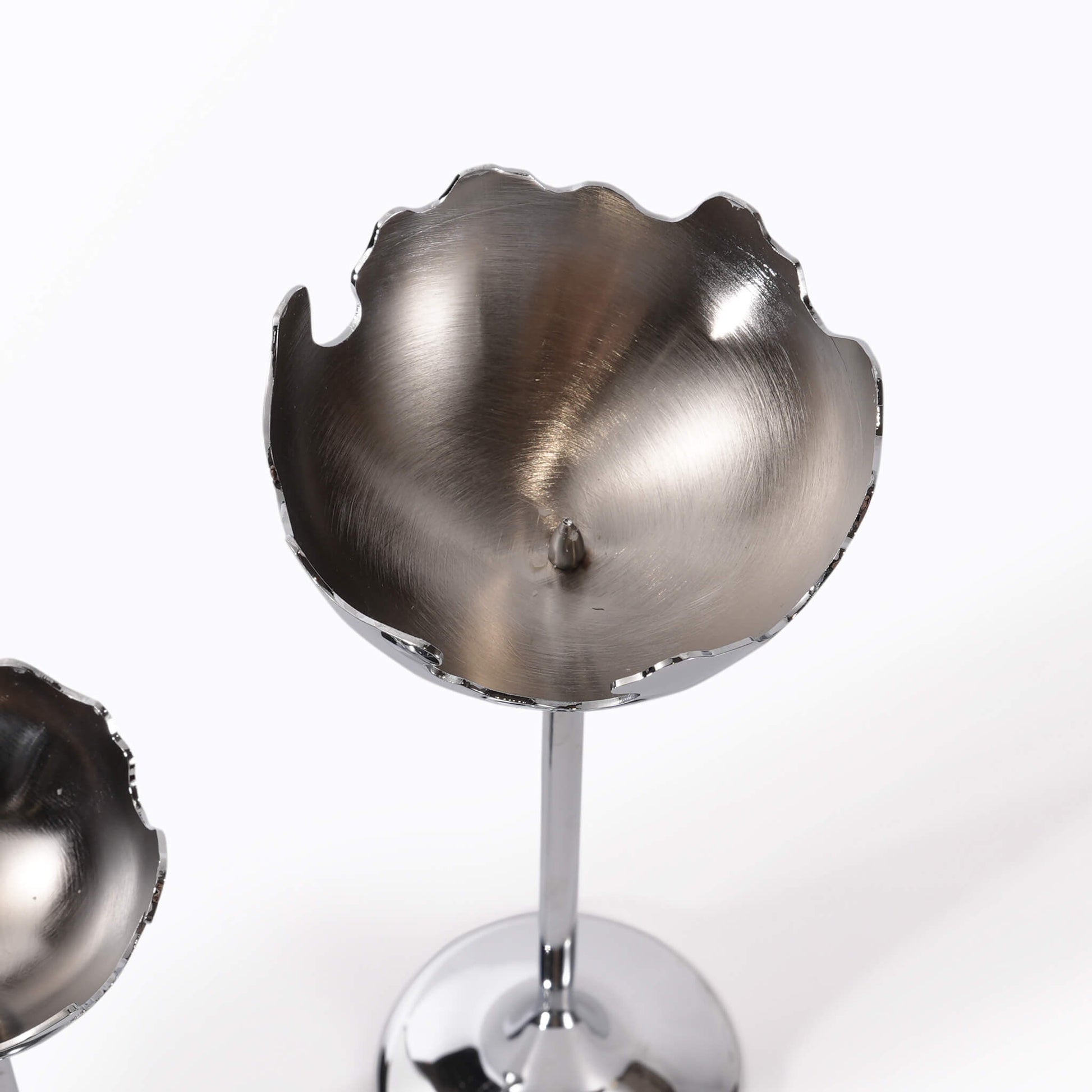 Top-down view into the cup of the moonlight silver candle holder, displaying the raw metal texture and internal candle spike