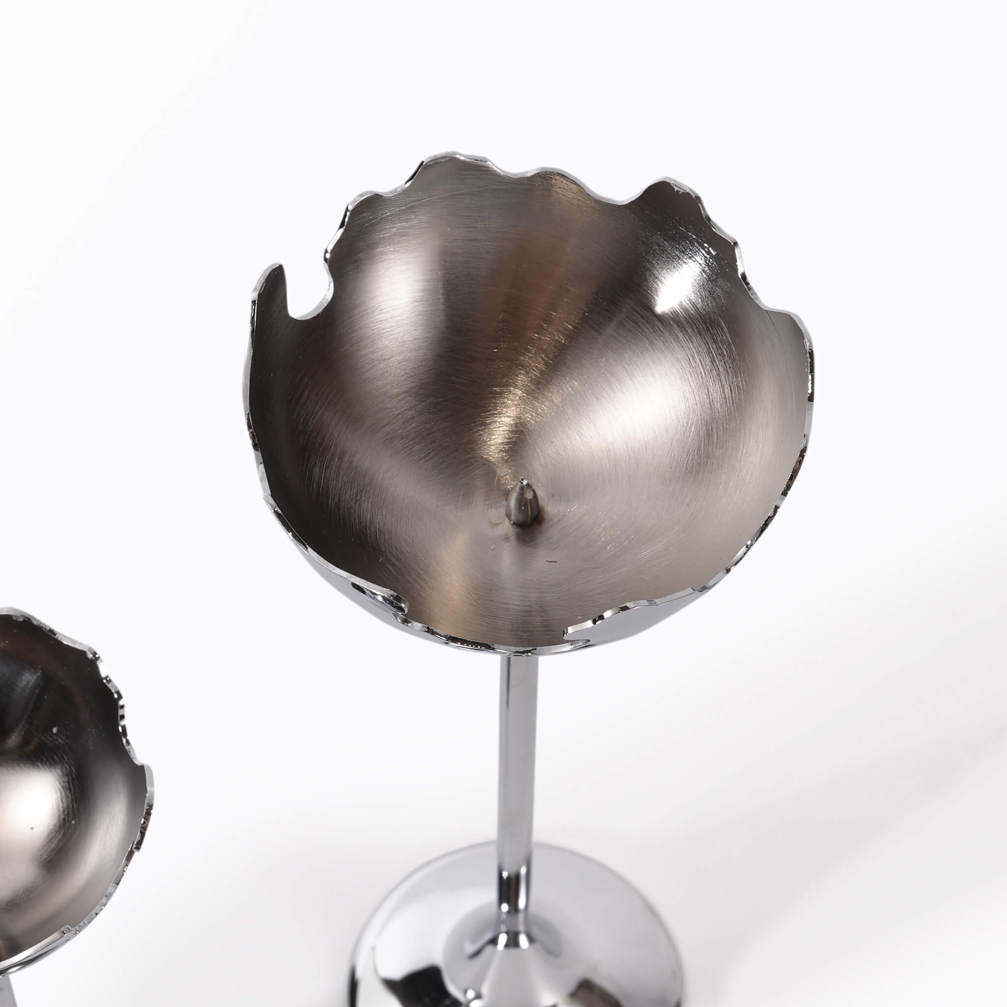 Top-down view into the cup of the moonlight silver candle holder, displaying the raw metal texture and internal candle spike