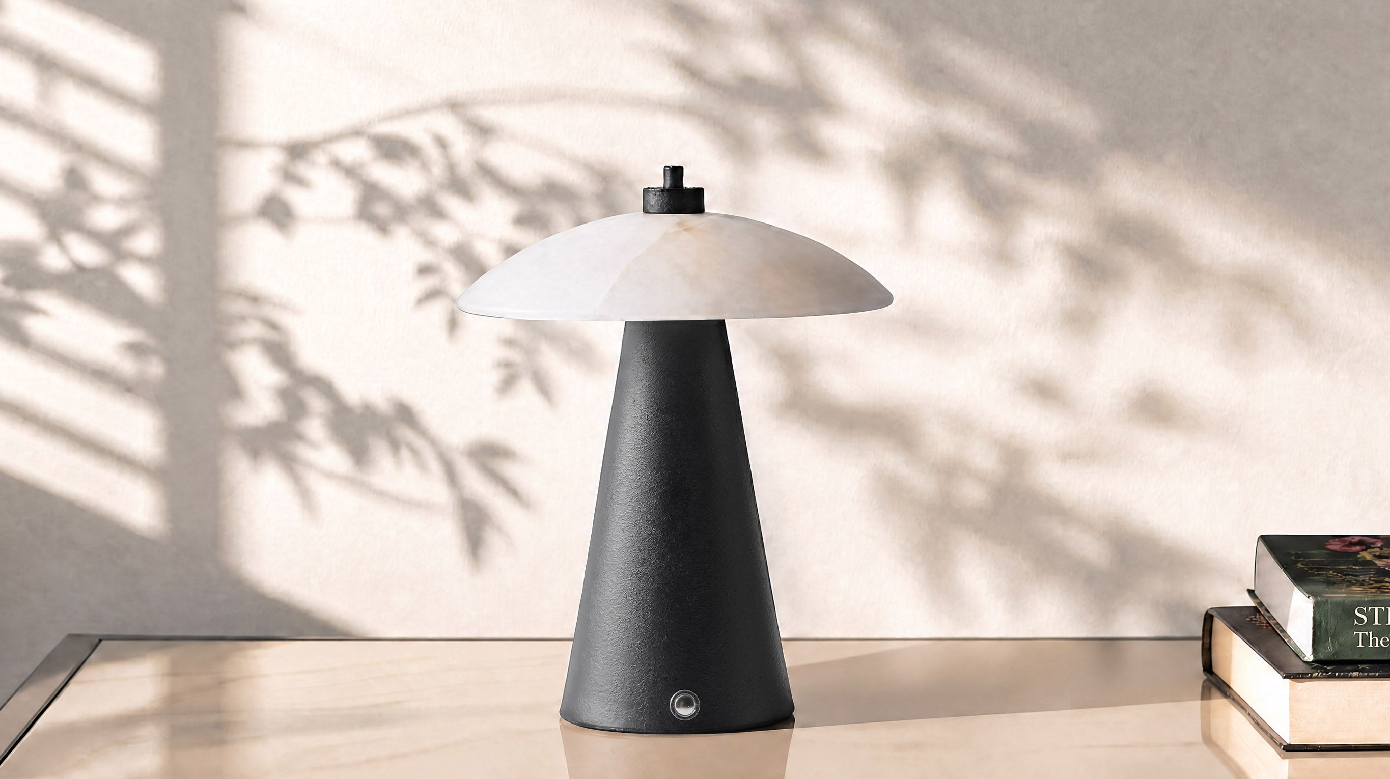 An elegant lifestyle shot of the artamore modern organic table lamp casting a soft ambient glow, perfectly embodying the warm minimalist aesthetic.