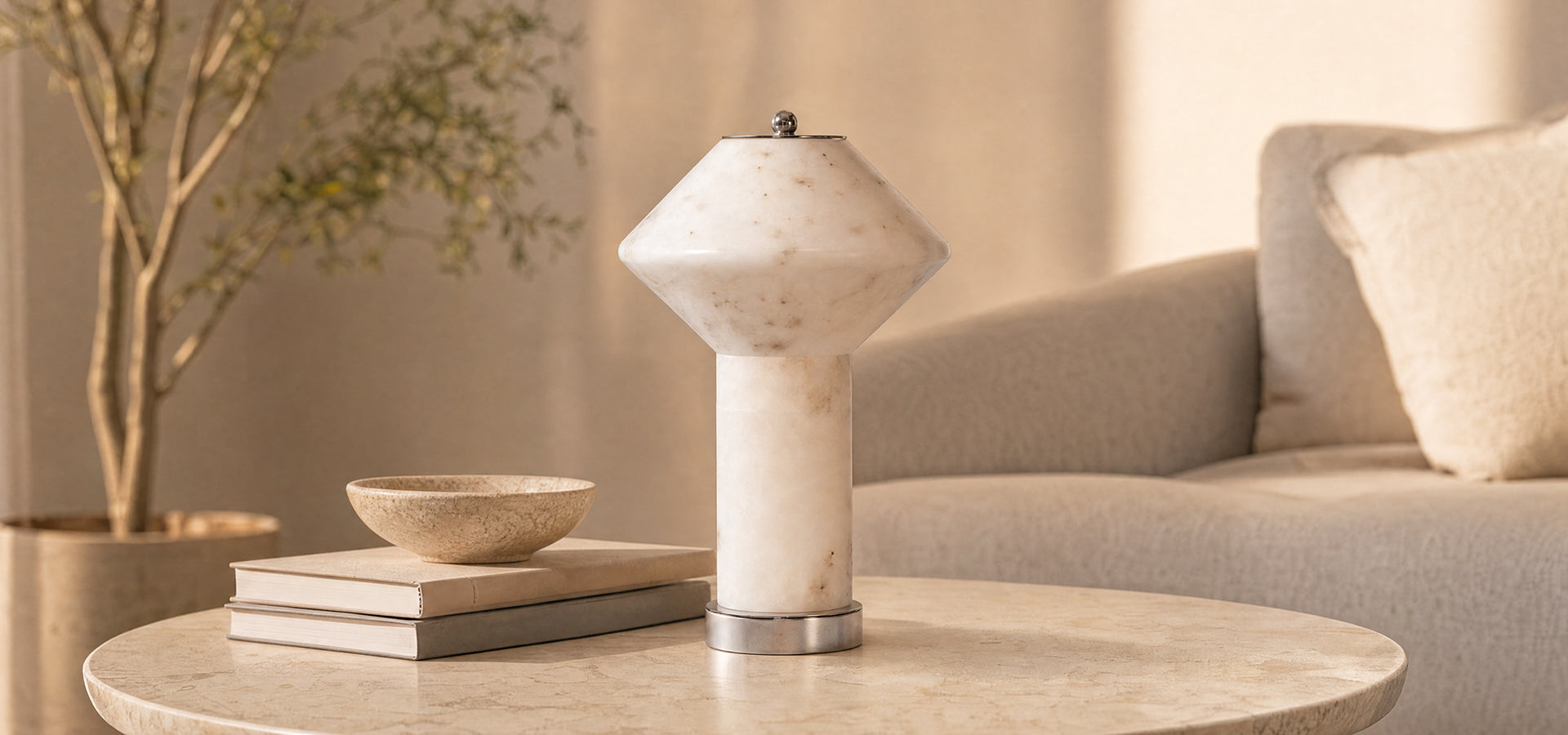 Msol Studio rechargeable natural marble table lamp with a geometric shade on a round coffee table in a warm minimalist living room.