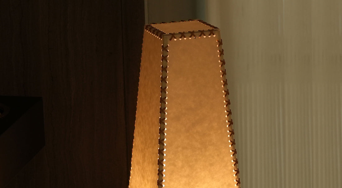 A close-up of the artamore table lamp's sturdy metal base structure, which perfectly grounds the delicate handmade parchment shade with modern stability.