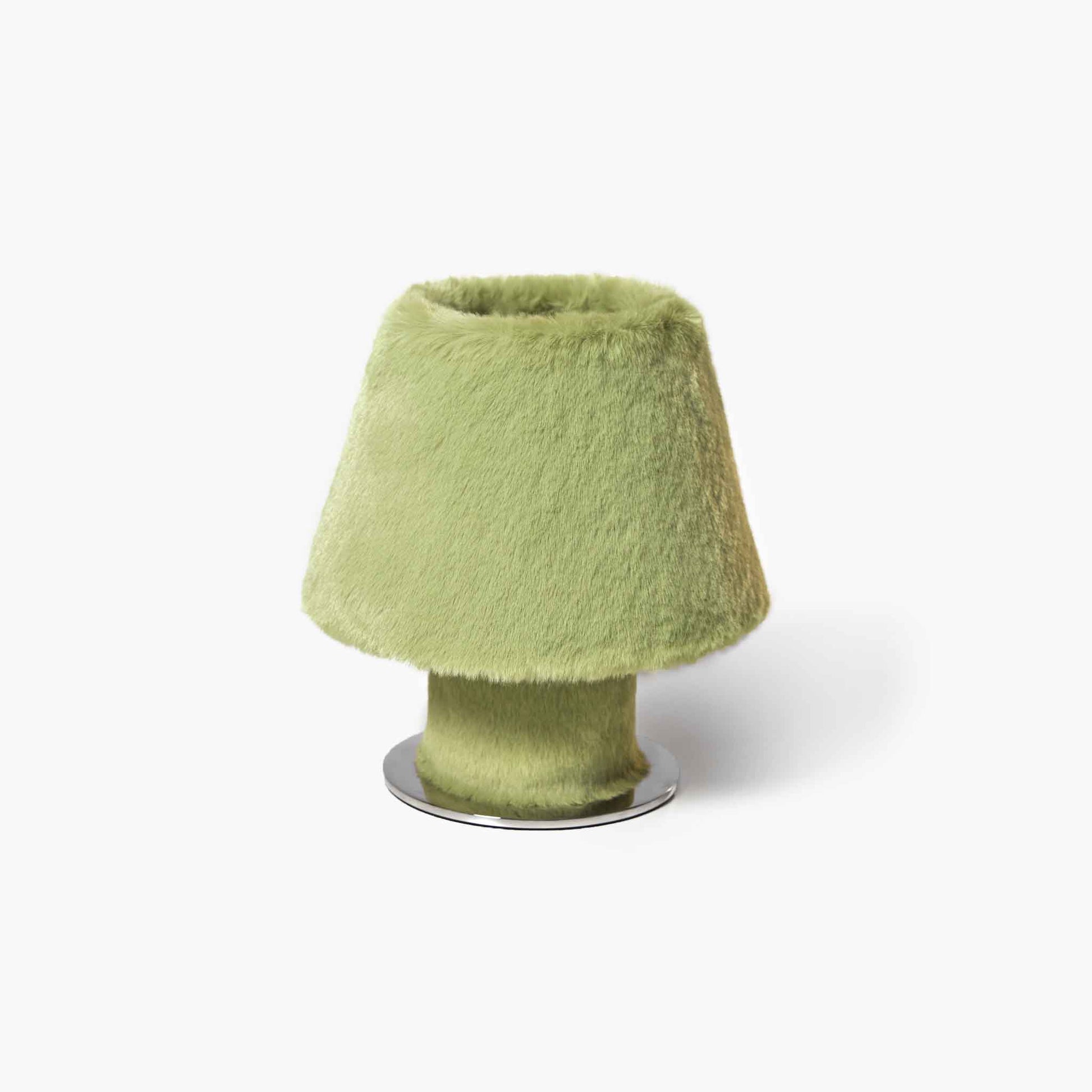 Detailed view of the pine green warm modern organic desk light filtering gentle beams through fur fibers.