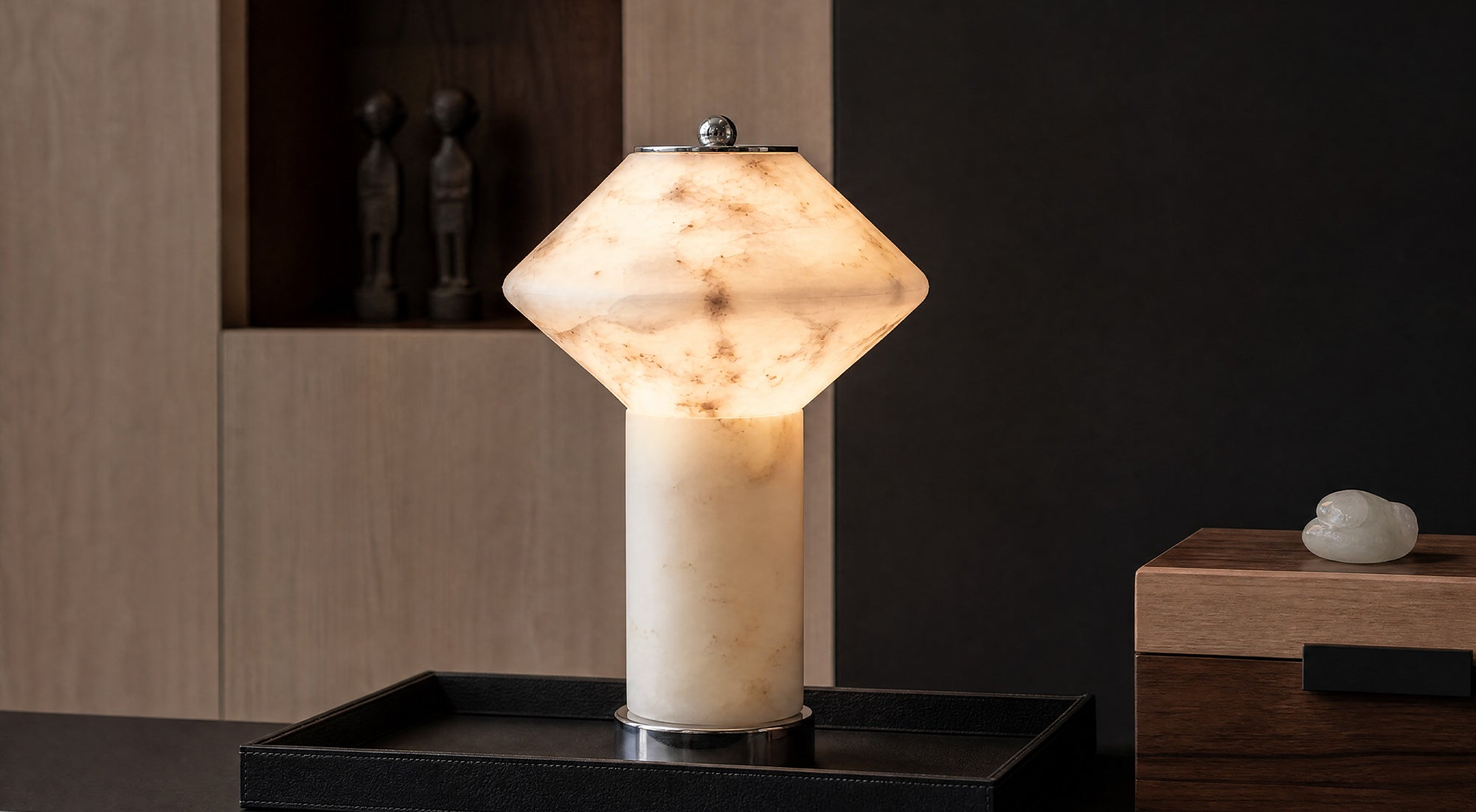 The artamore rechargeable marble table lamp features premium natural stone with unique veining, emitting a warm ambient glow in a modern minimalist living space.