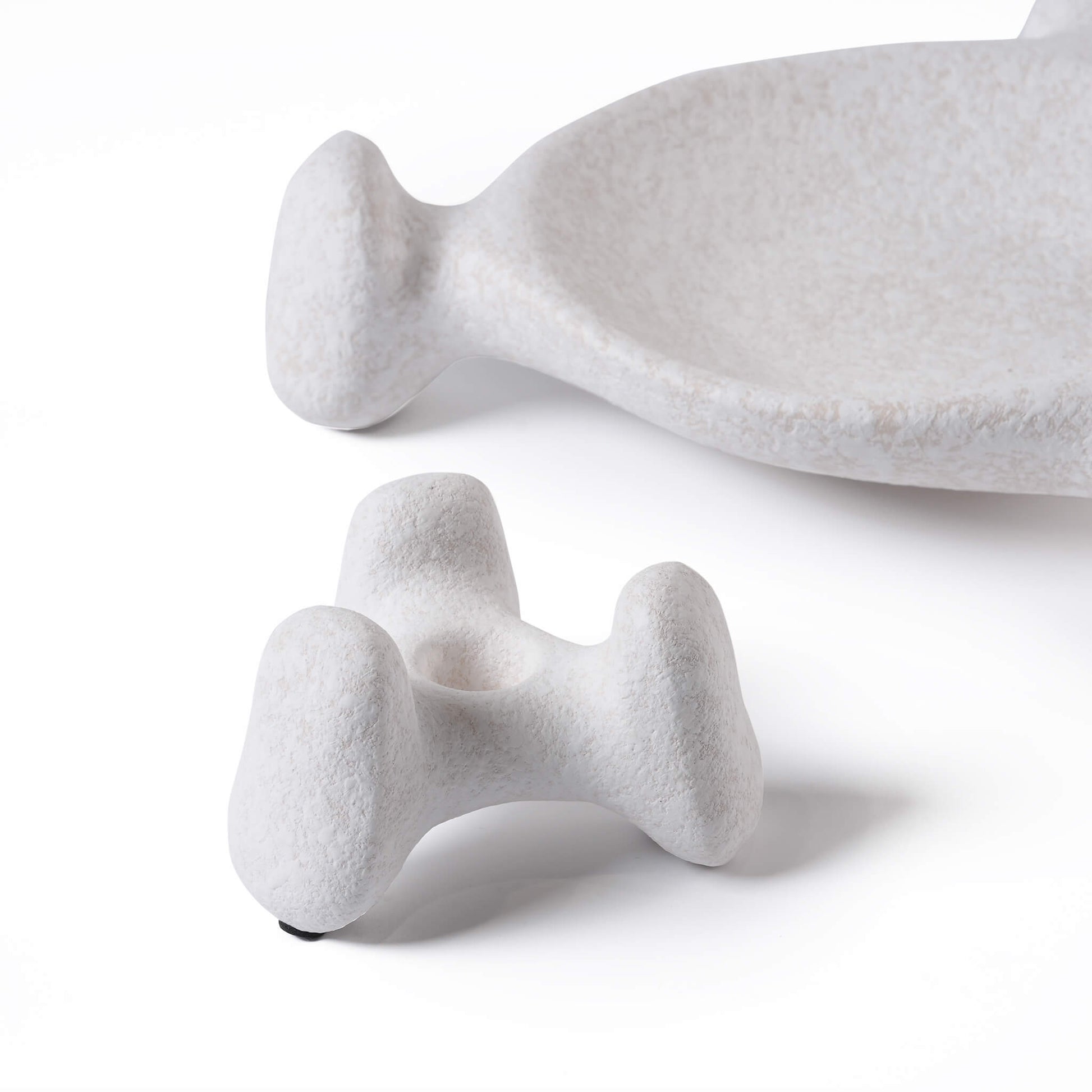 Close up of a quirky three-leg ceramic candle base showing the half-glaze matte finish